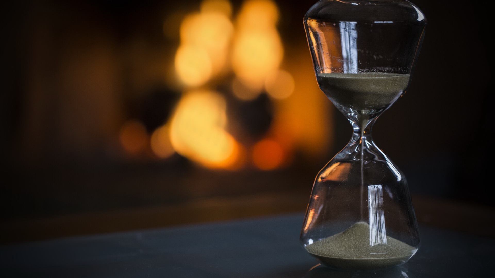 Стеклянные песочные часы на столе 