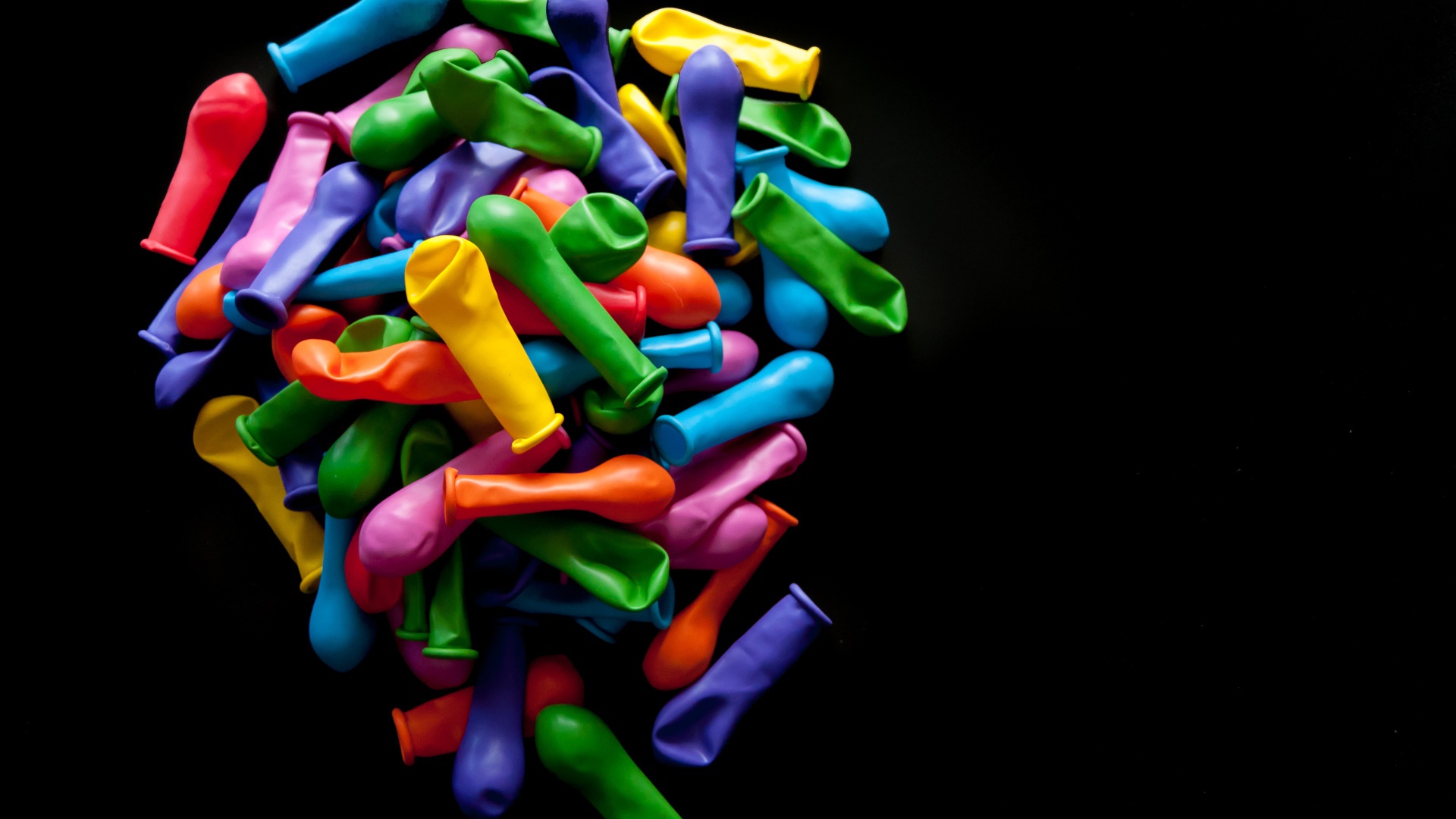 Много разноцветных шариком на черном фоне 