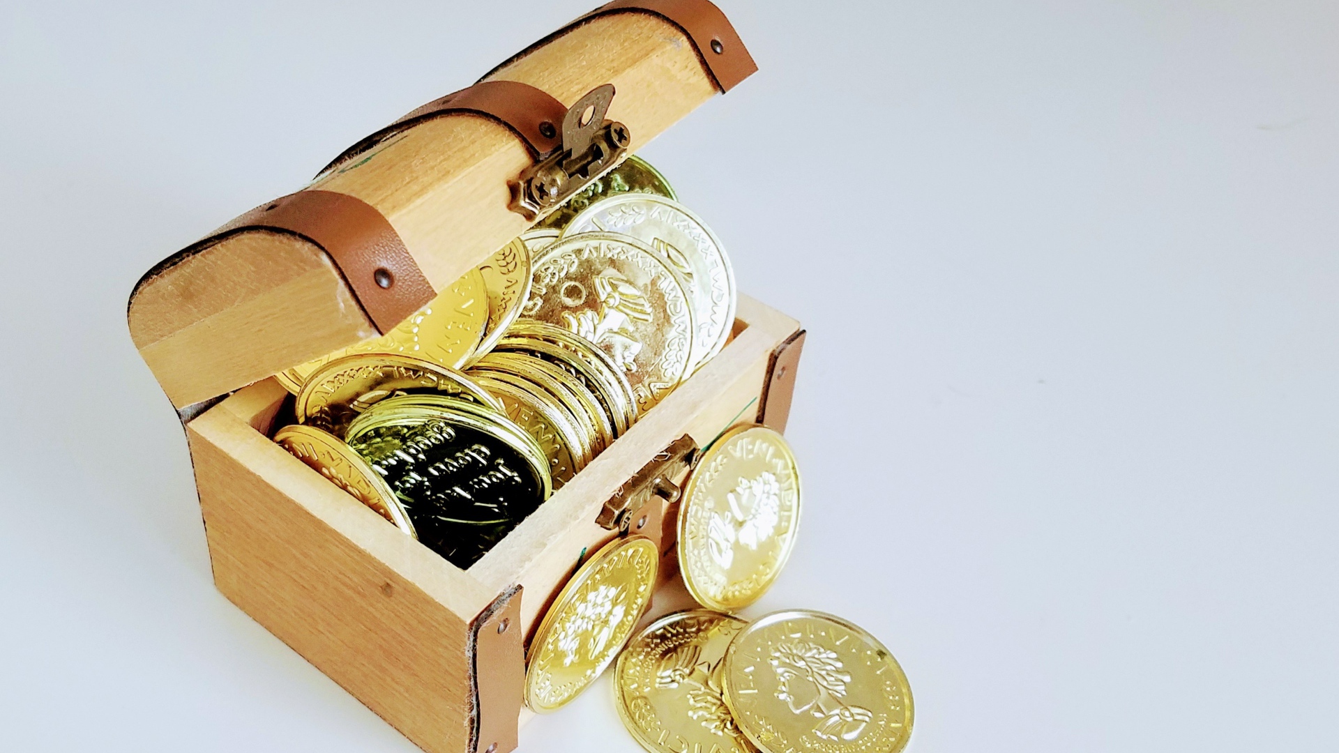 Золотые монеты в сундуке на сером фоне