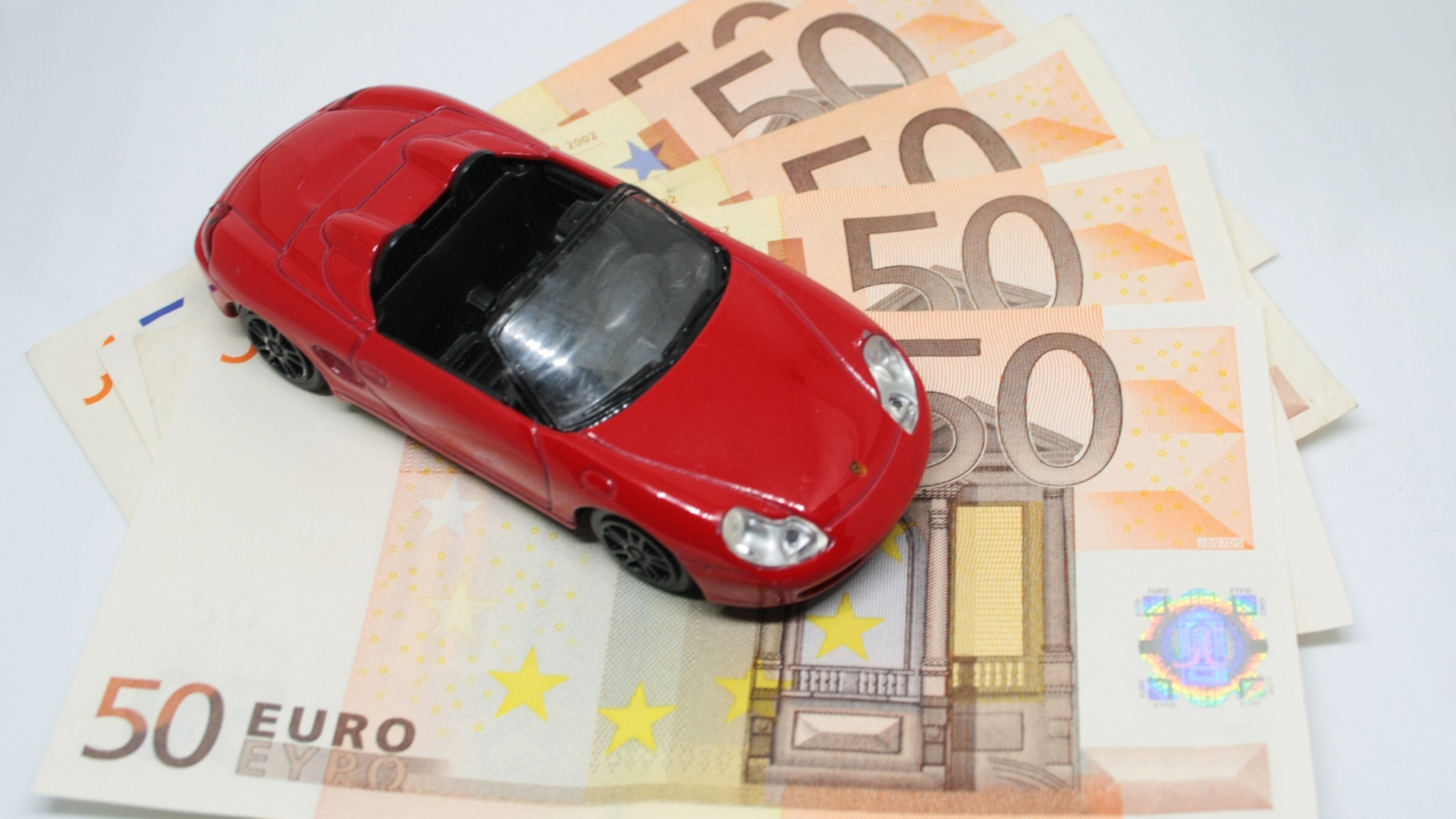 Red toy car with euro bills