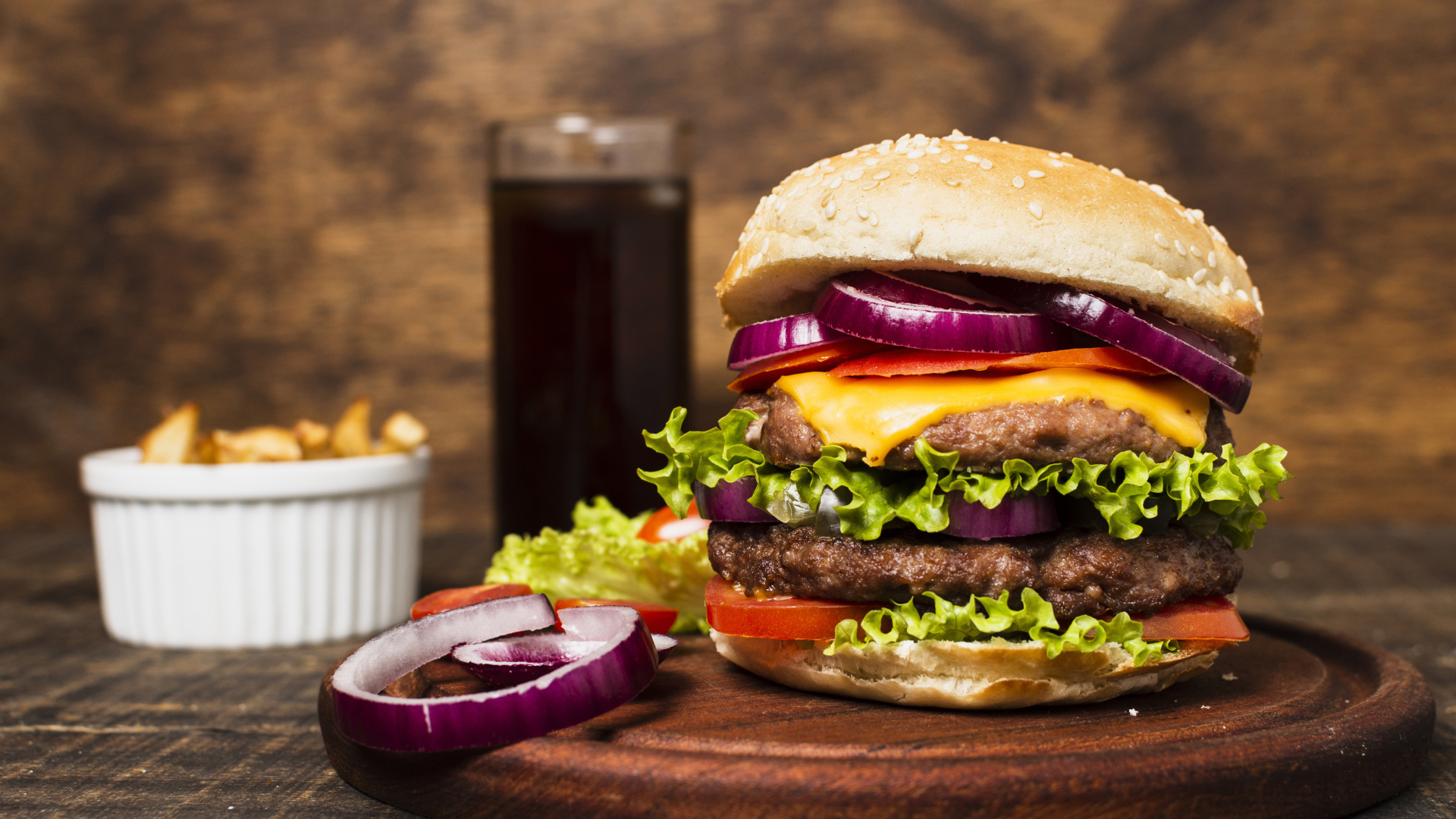 Большой гамбургер на столе с колой и картофелем фри 