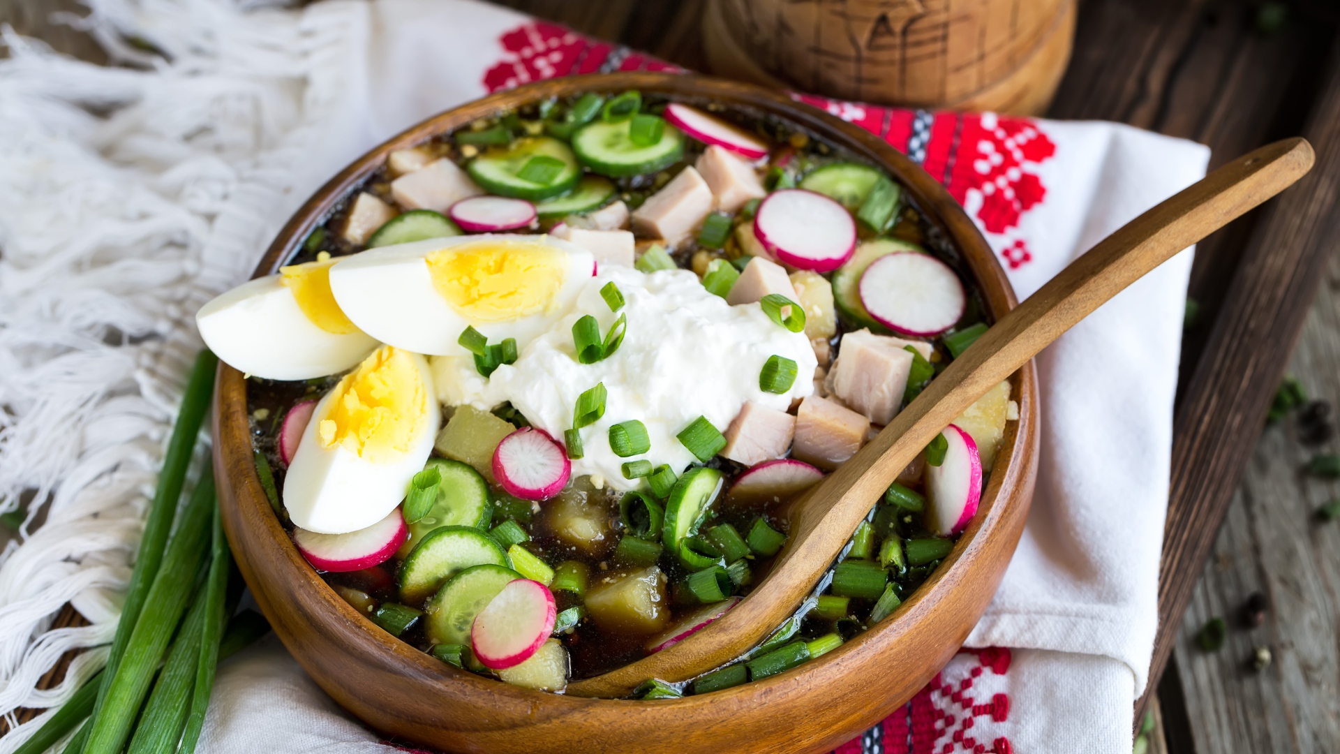 Холодная окрошка в деревянной миске на столе 