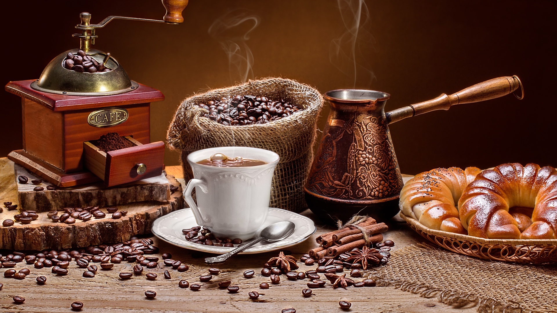 Чашка кофе на столе с круассанами и кофемолкой
