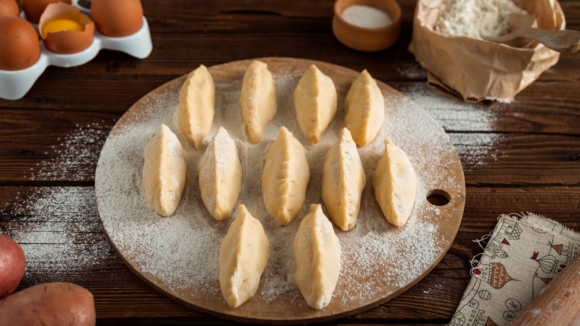 Вареники с картошкой на доске с мукой