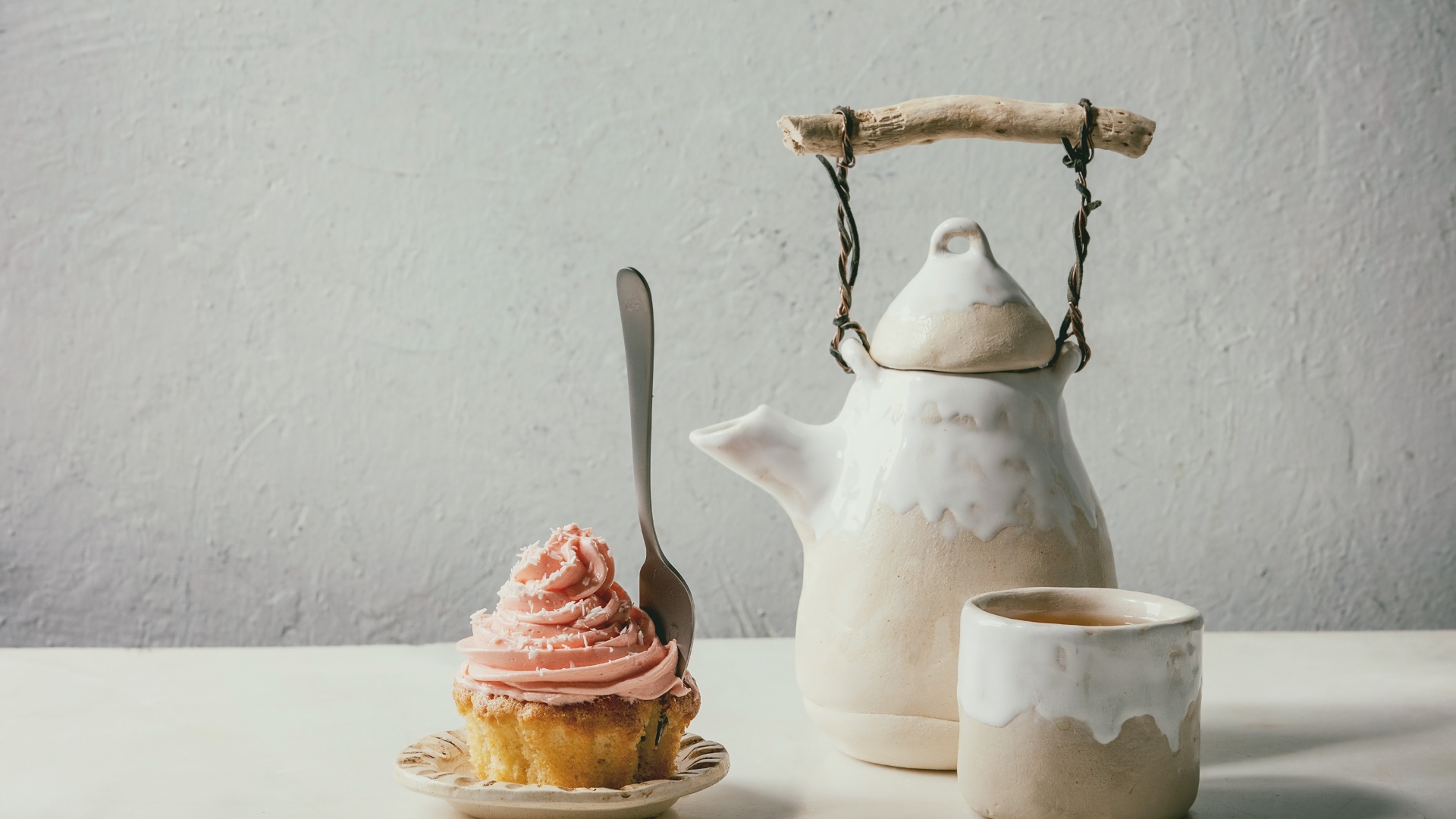 Чайник с чашкой на столе с кексом