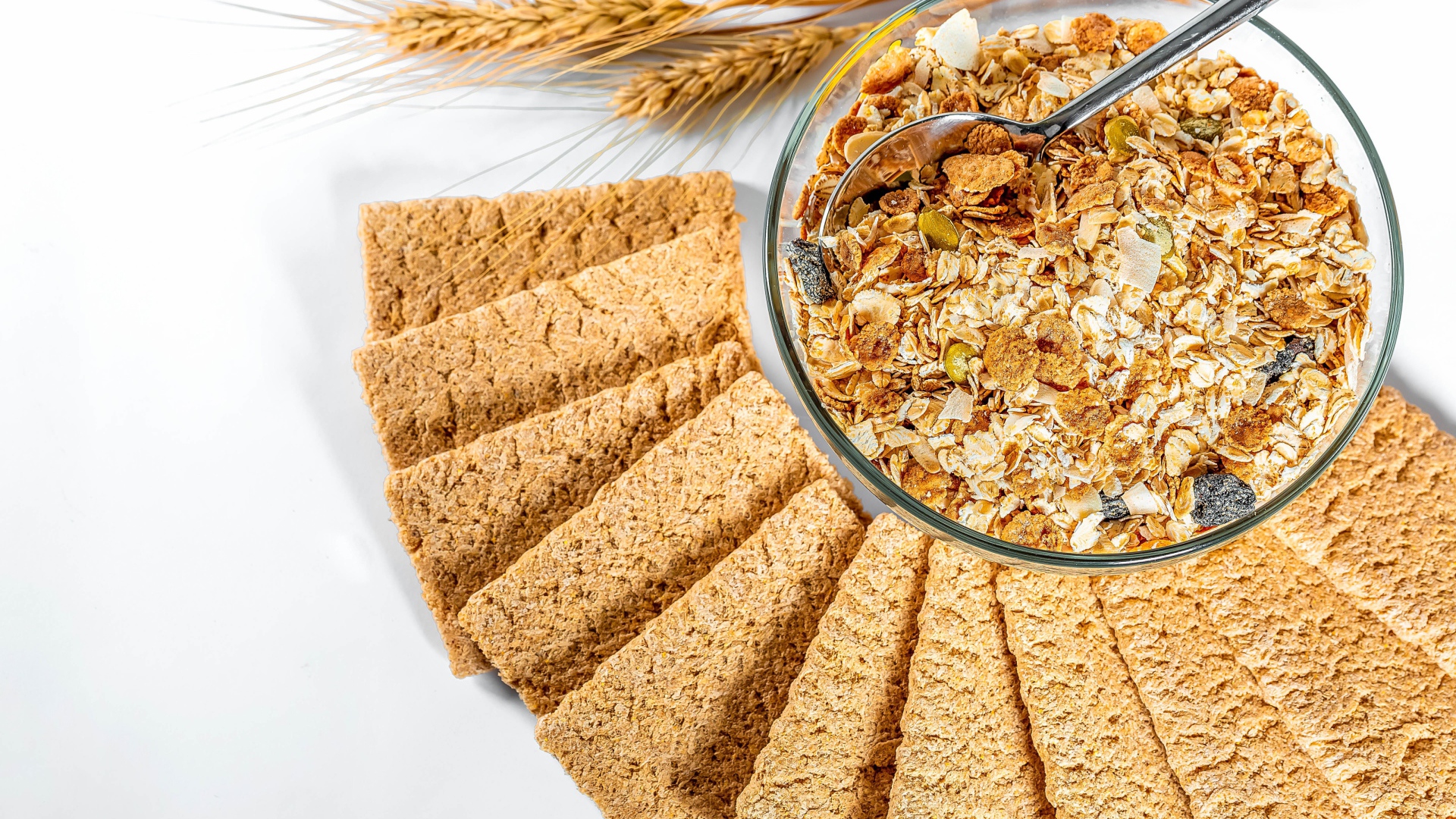 Мюсли в тарелке на столе с хлебцами 