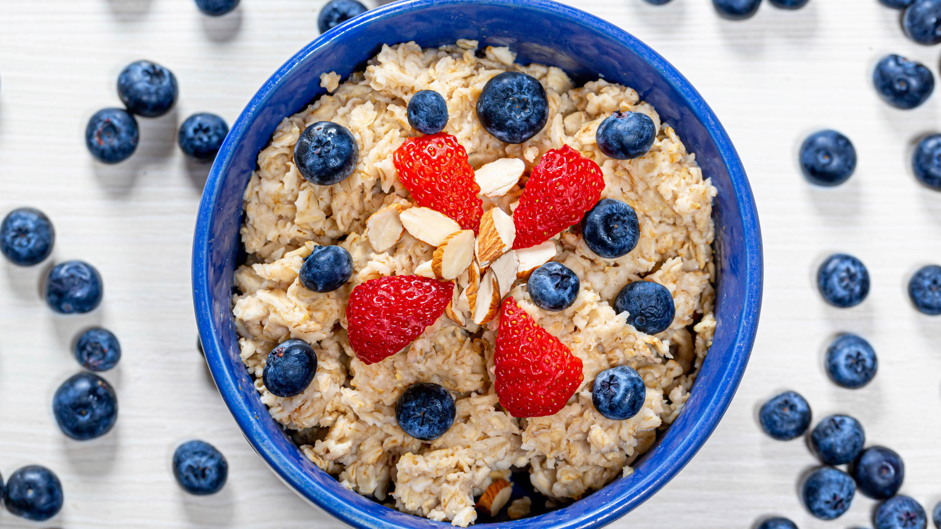 Овсяная каша в тарелке с ягодами черники и клубники 