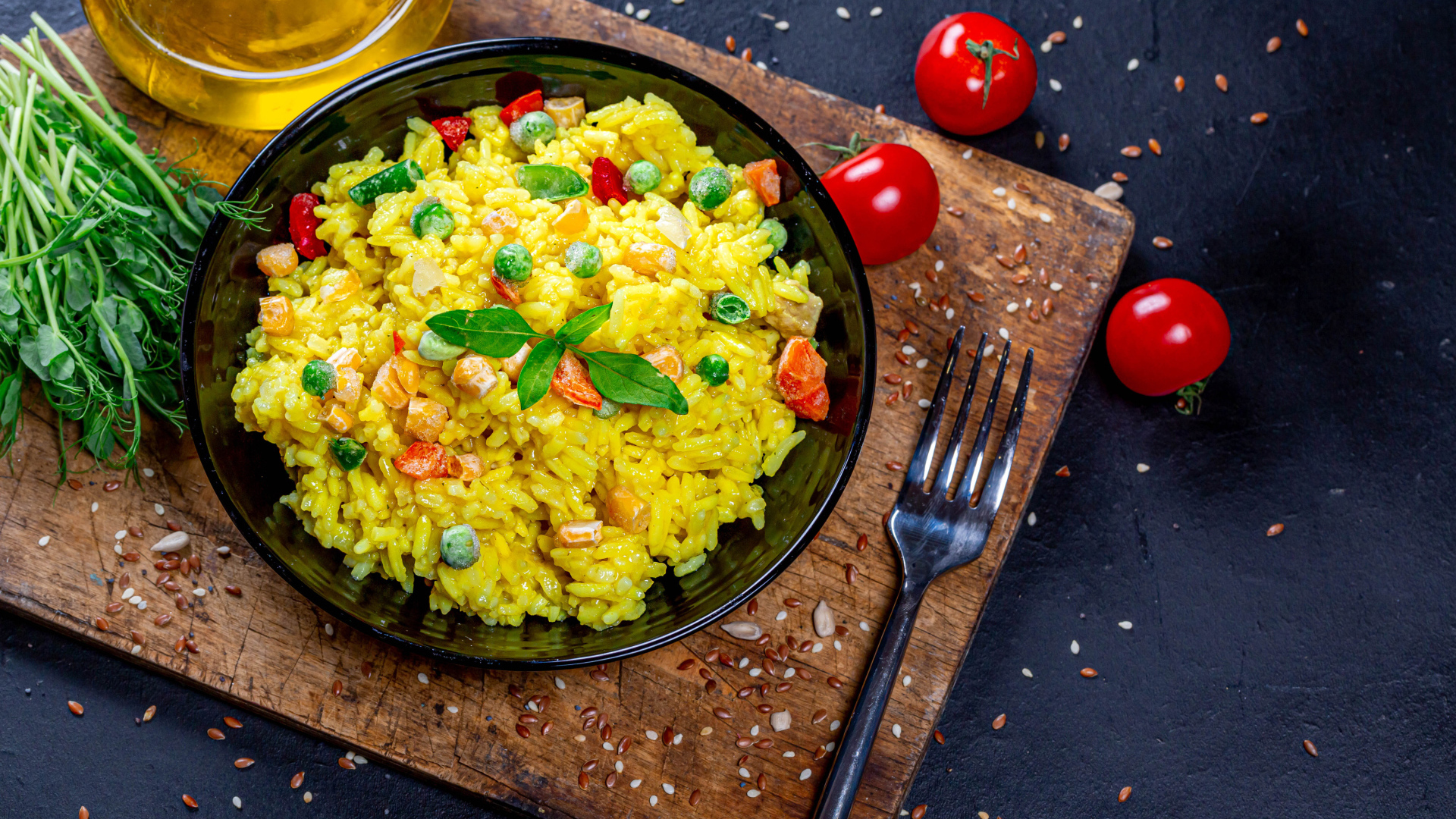 Рис с овощами на столе с маслом, зеленью и помидорами 