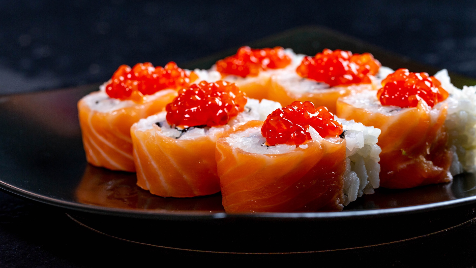 Роллы с красной рыбой и икрой на тарелке