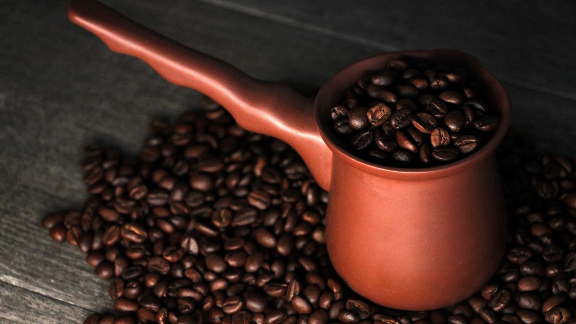 Турка с кофейными зернами на столе 