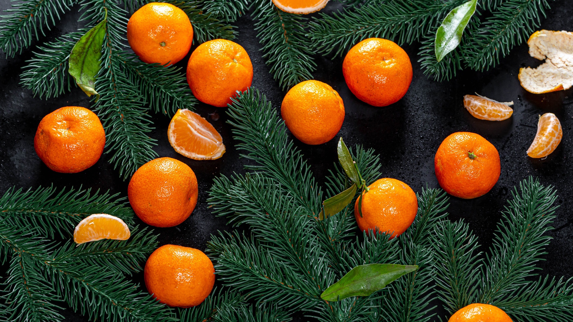 Много мандаринов на столе с еловыми ветками