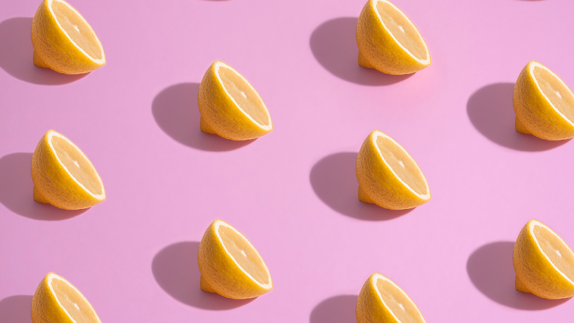 Половинки лимона на розовом фоне
