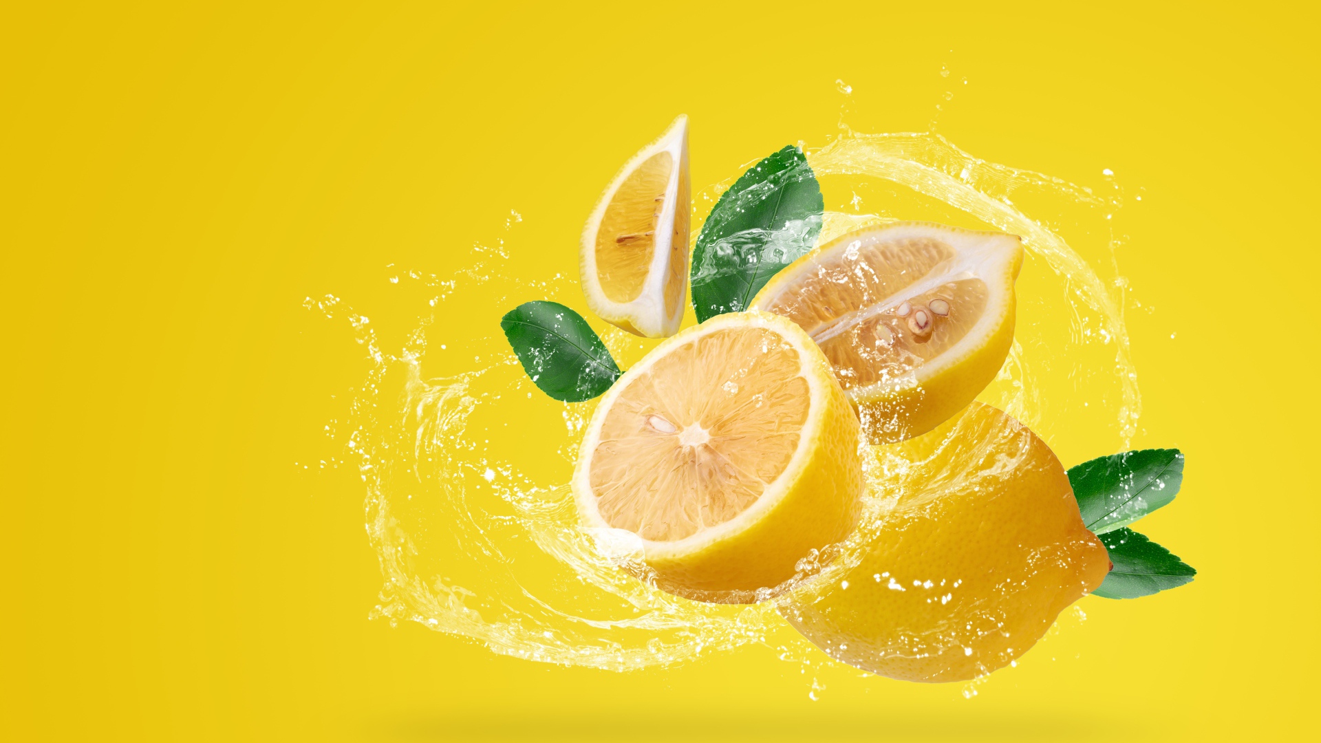 Лимоны в брызгах воды на желтом фоне