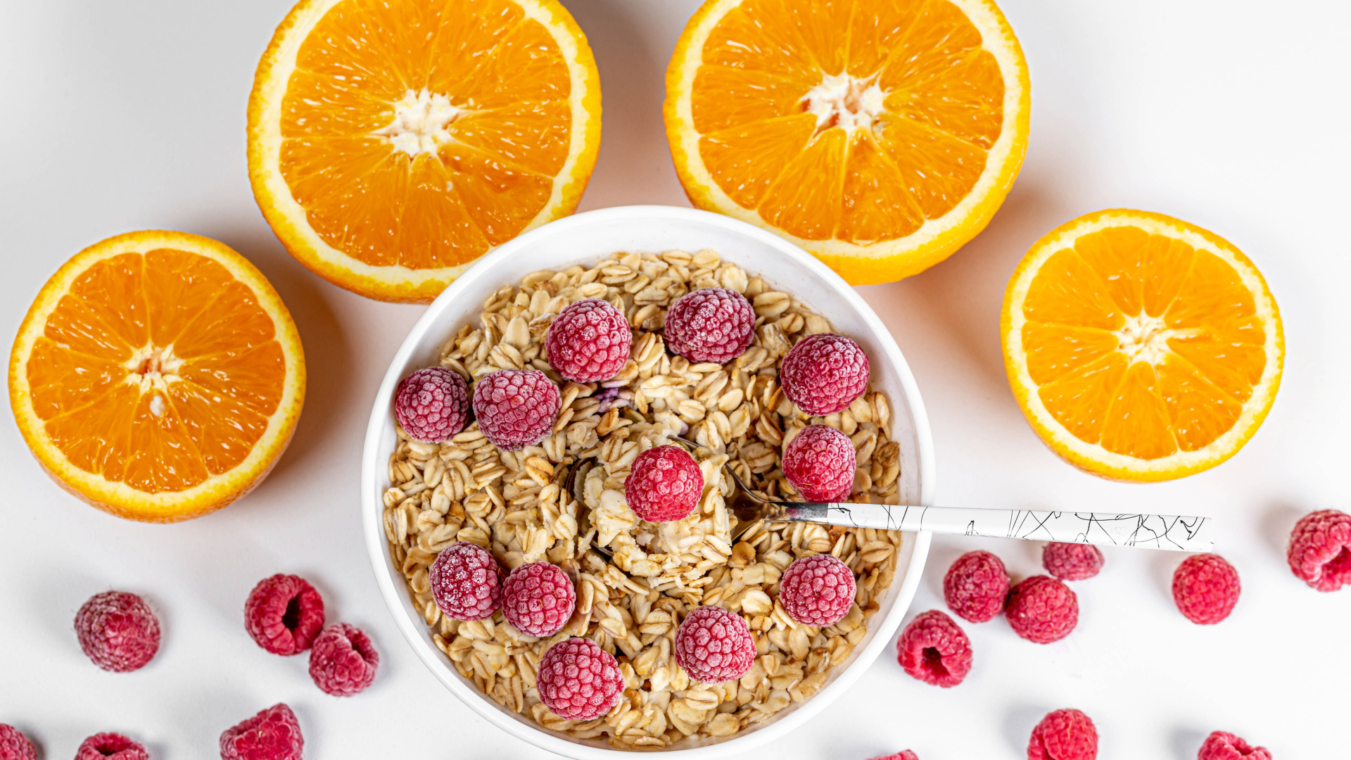 Овсяные хлопья с малиной на белом фоне с апельсинами