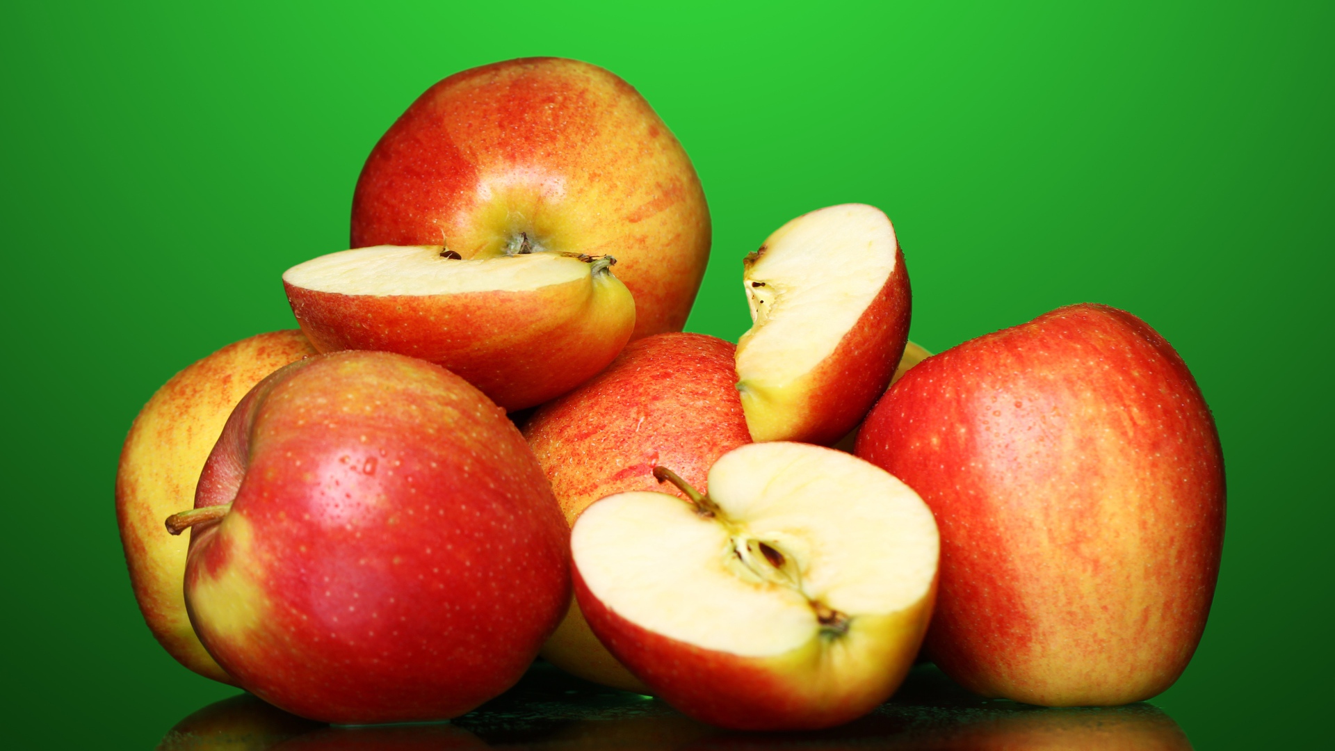 Спелые вкусные красные яблоки на зеленом фоне