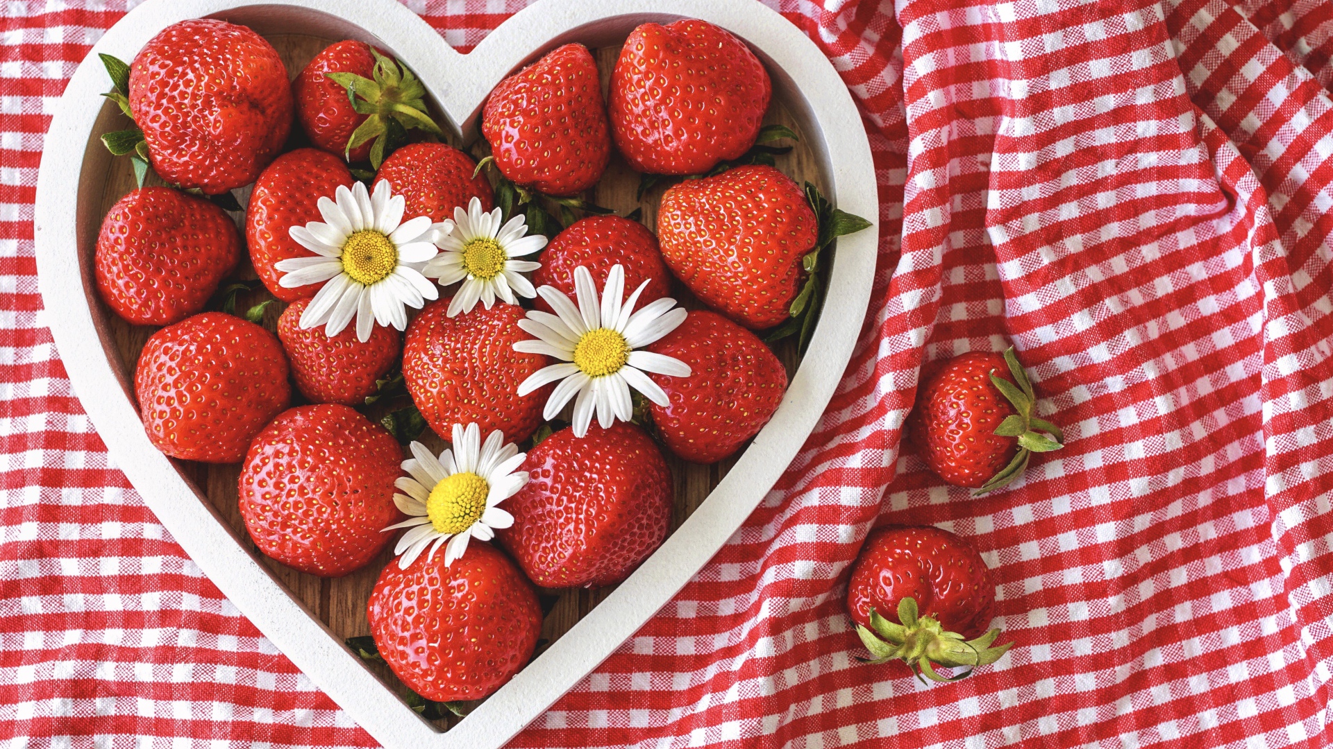 Спелая красная клубника в коробке в форме сердца с ромашками