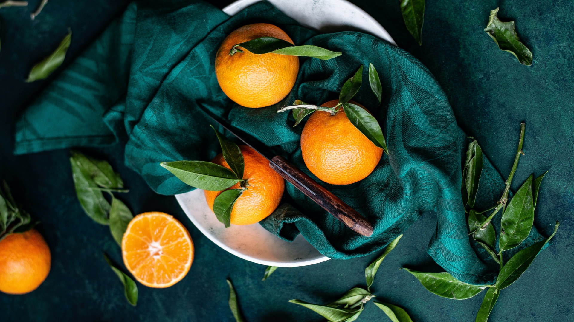Ripe tangerines on the table in a scarf