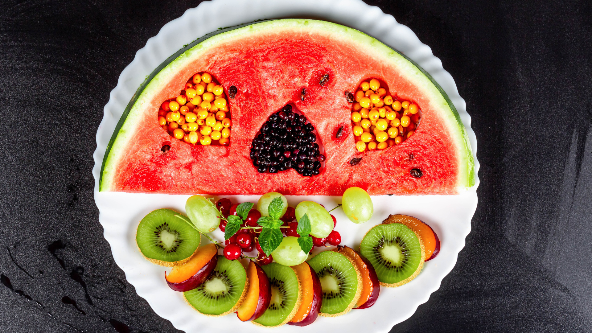 Арбуз на тарелке с ягодами 