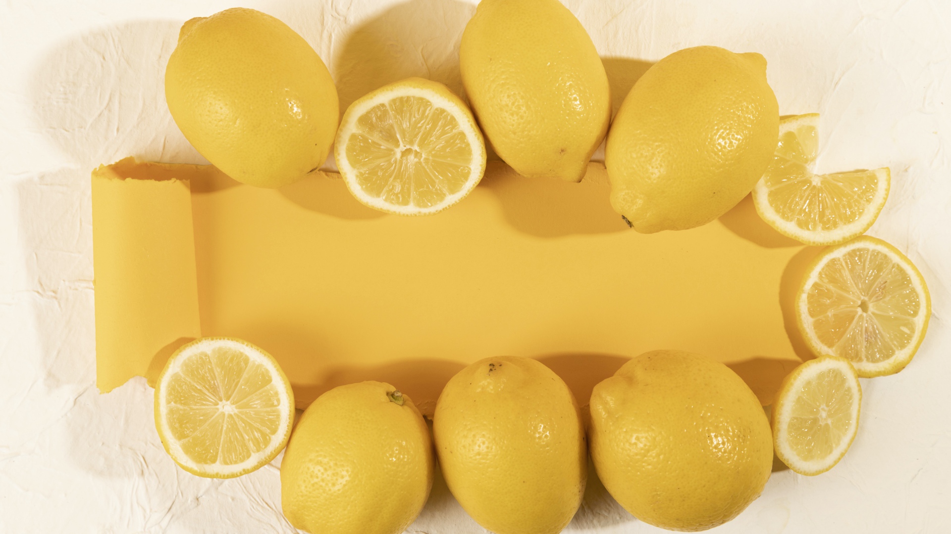 Желтые лимоны на белом фоне с листом бумаги