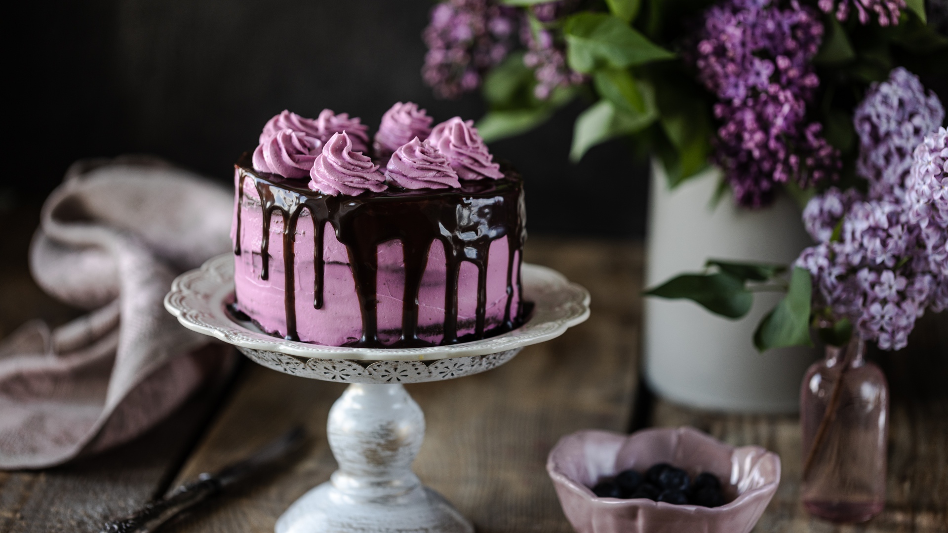 Ягодный торт с шоколадом на столе с сиренью 