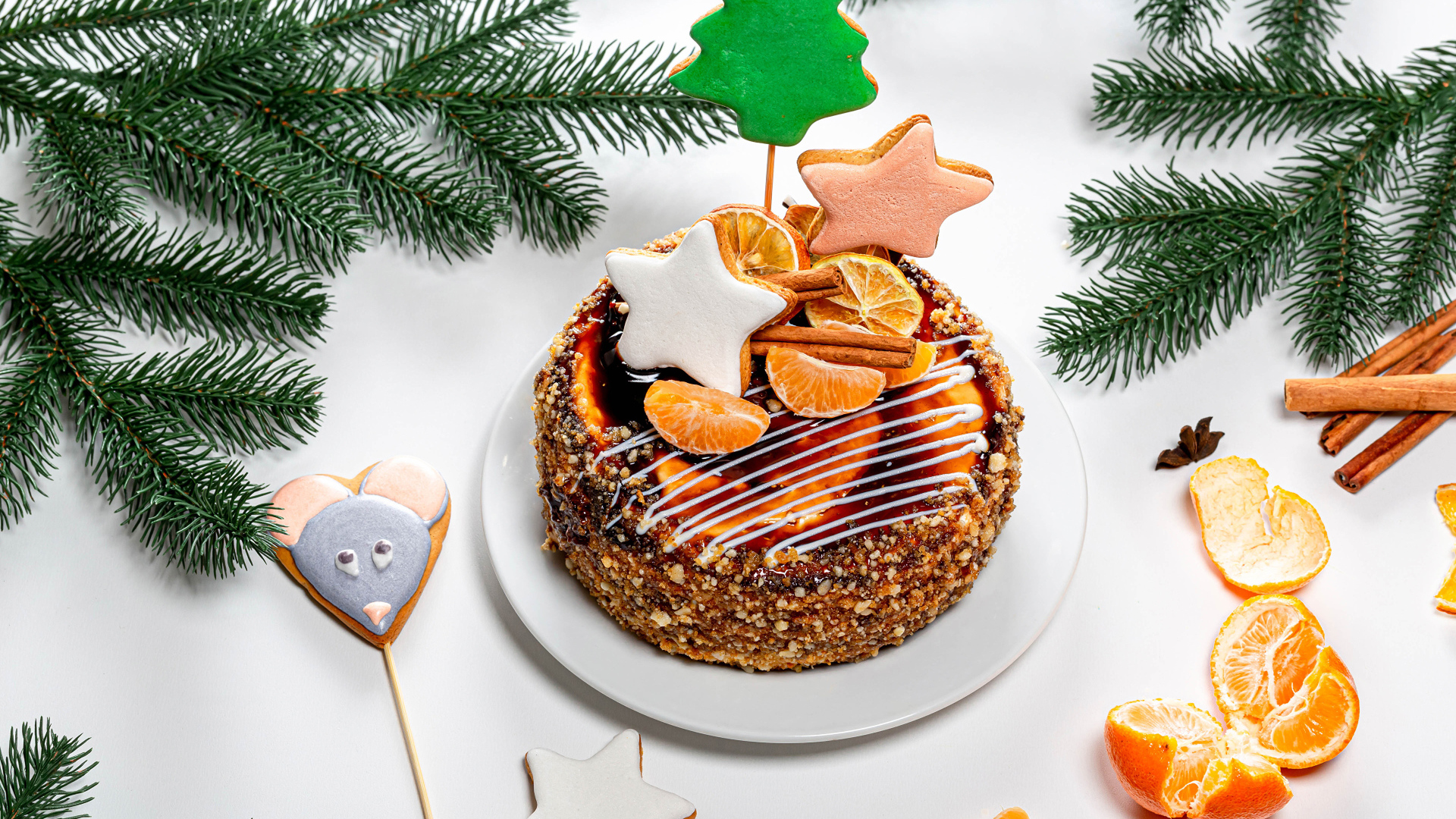Торт с мандаринами и печеньем на столе с еловой веткой
