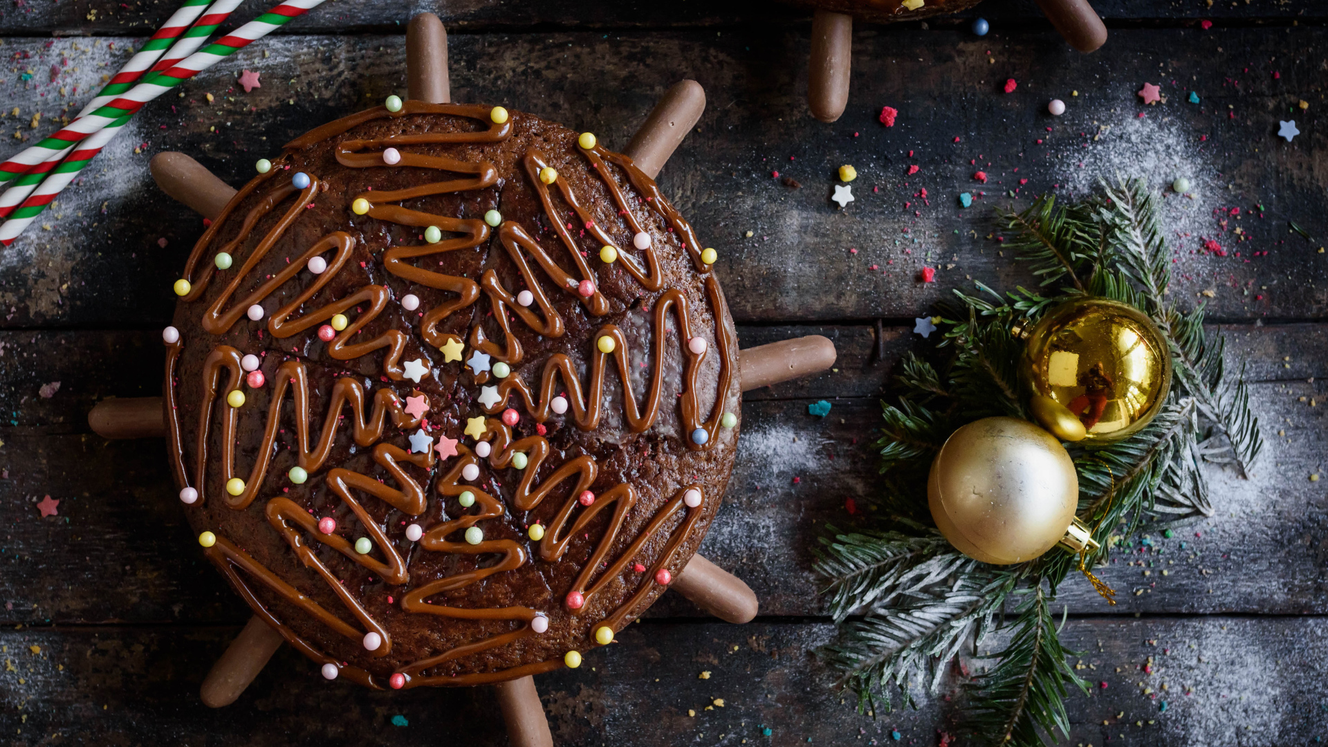 Шоколадное пирожное на столе с еловыми игрушками 