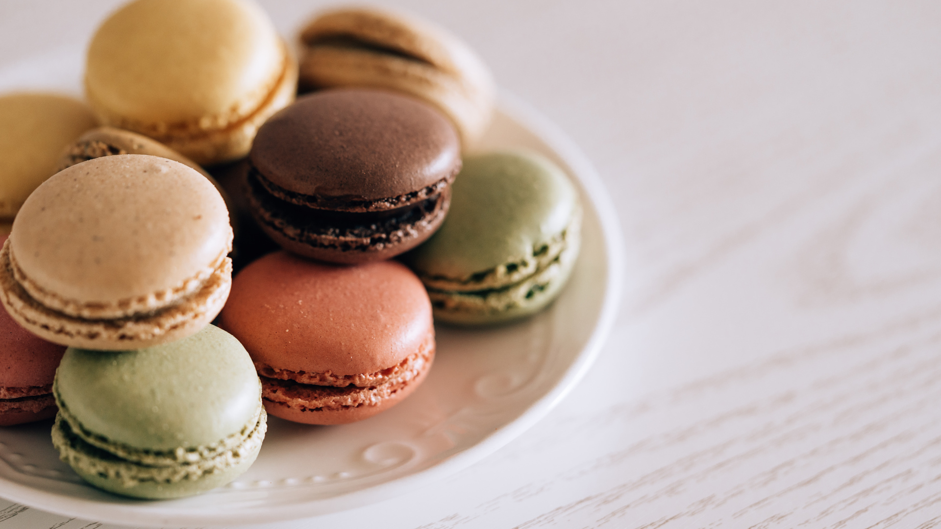 Разноцветный свежий десерт макарон на большой тарелке 