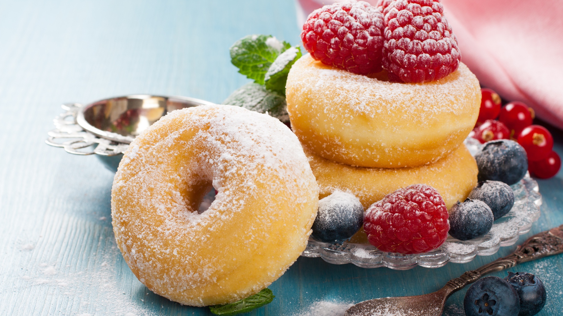 Вкусные пышные пончики с ягодами черники и малины с сахарной пудрой 