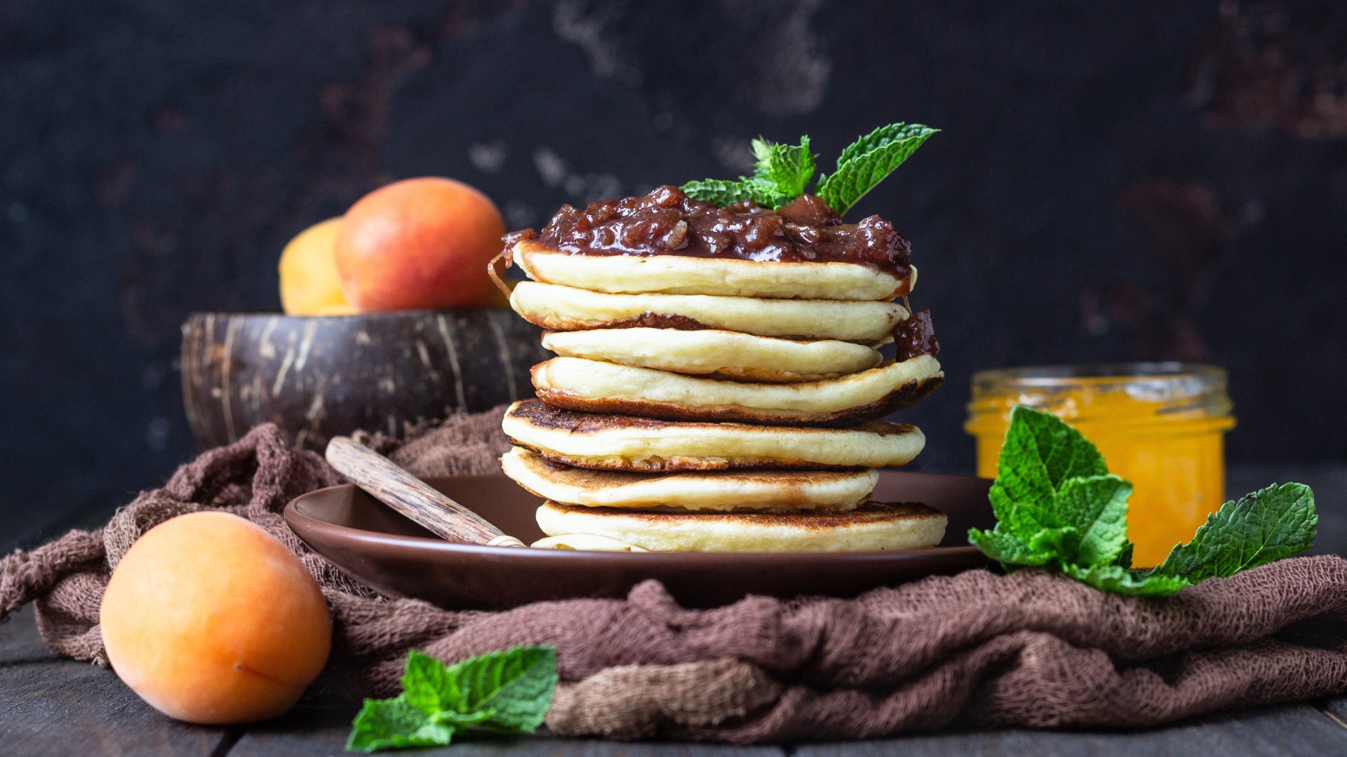 Вкусные оладьи на тарелке с джемом