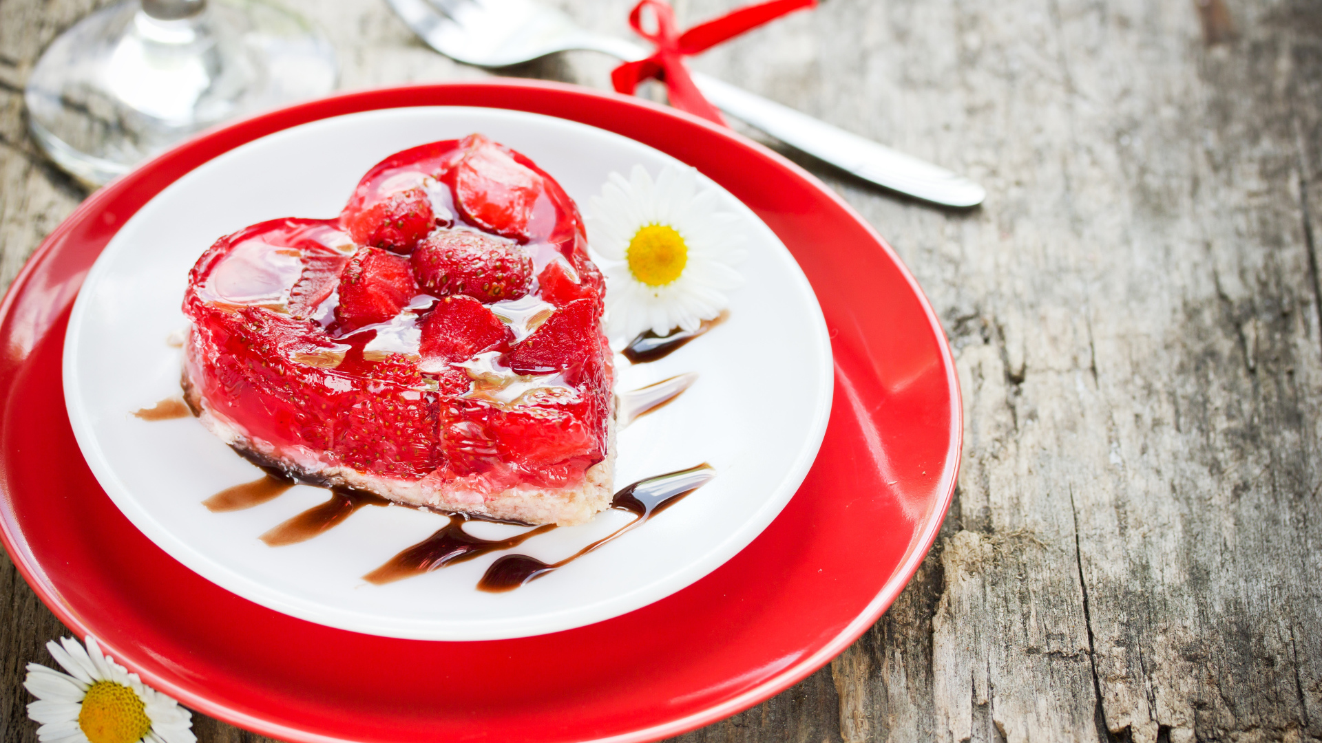 Пирожное с клубникой в форме сердца на тарелке с ромашками