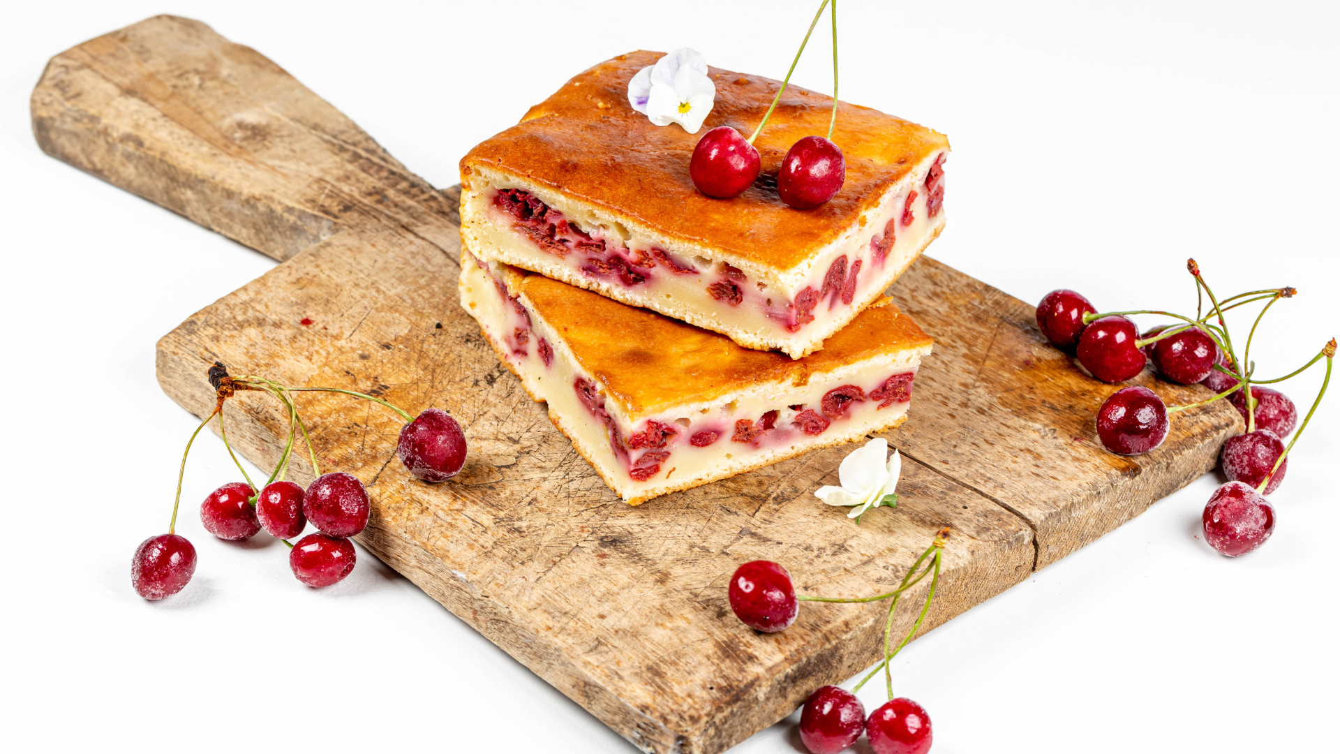 Пирог с вишнями на доске на белом фоне