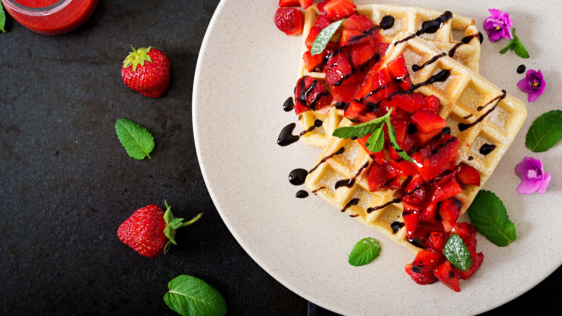 Сладкие вафли на тарелке с кусочками клубники