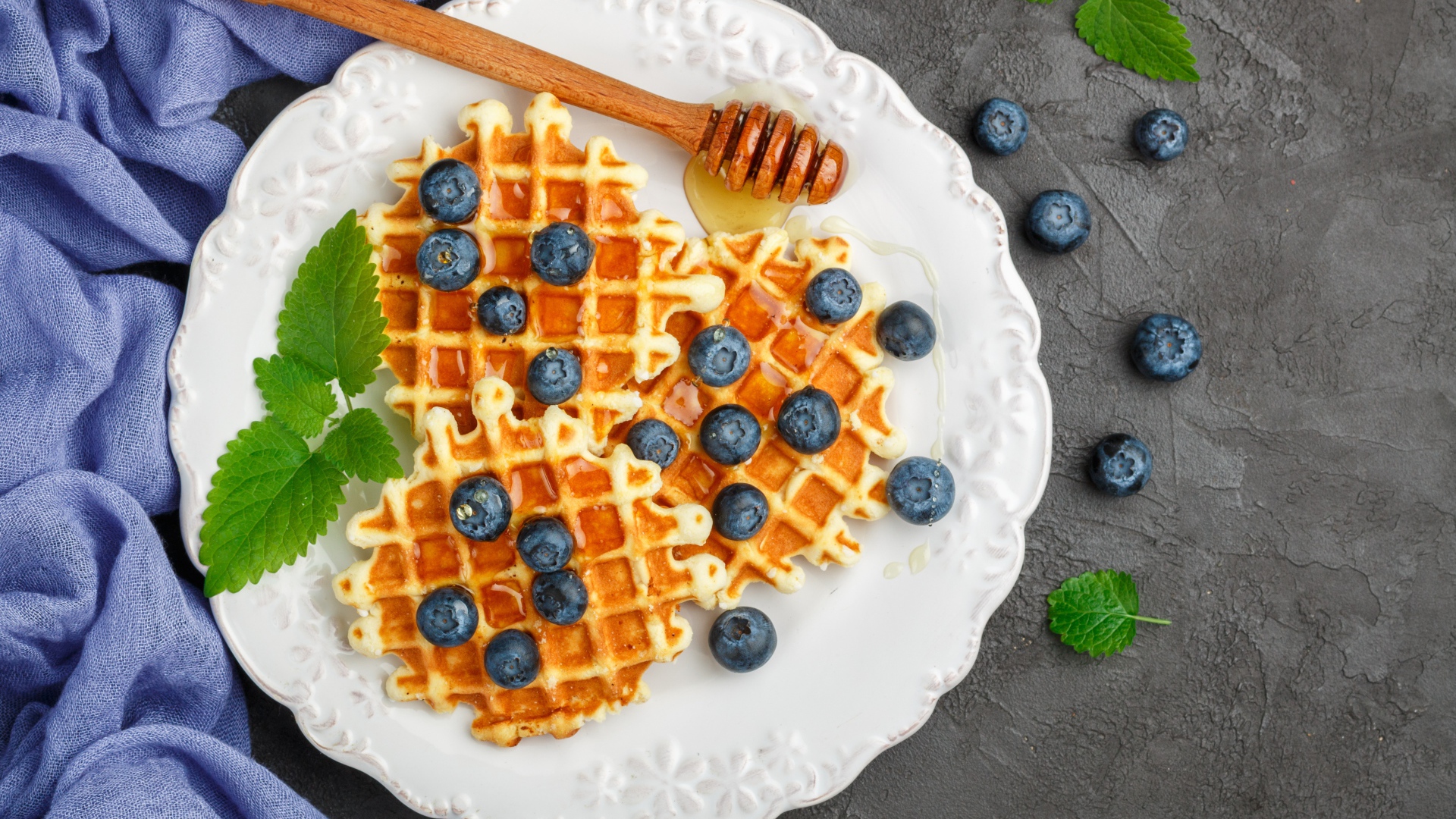 Сладкие вафли с медом на тарелке с ягодами черники