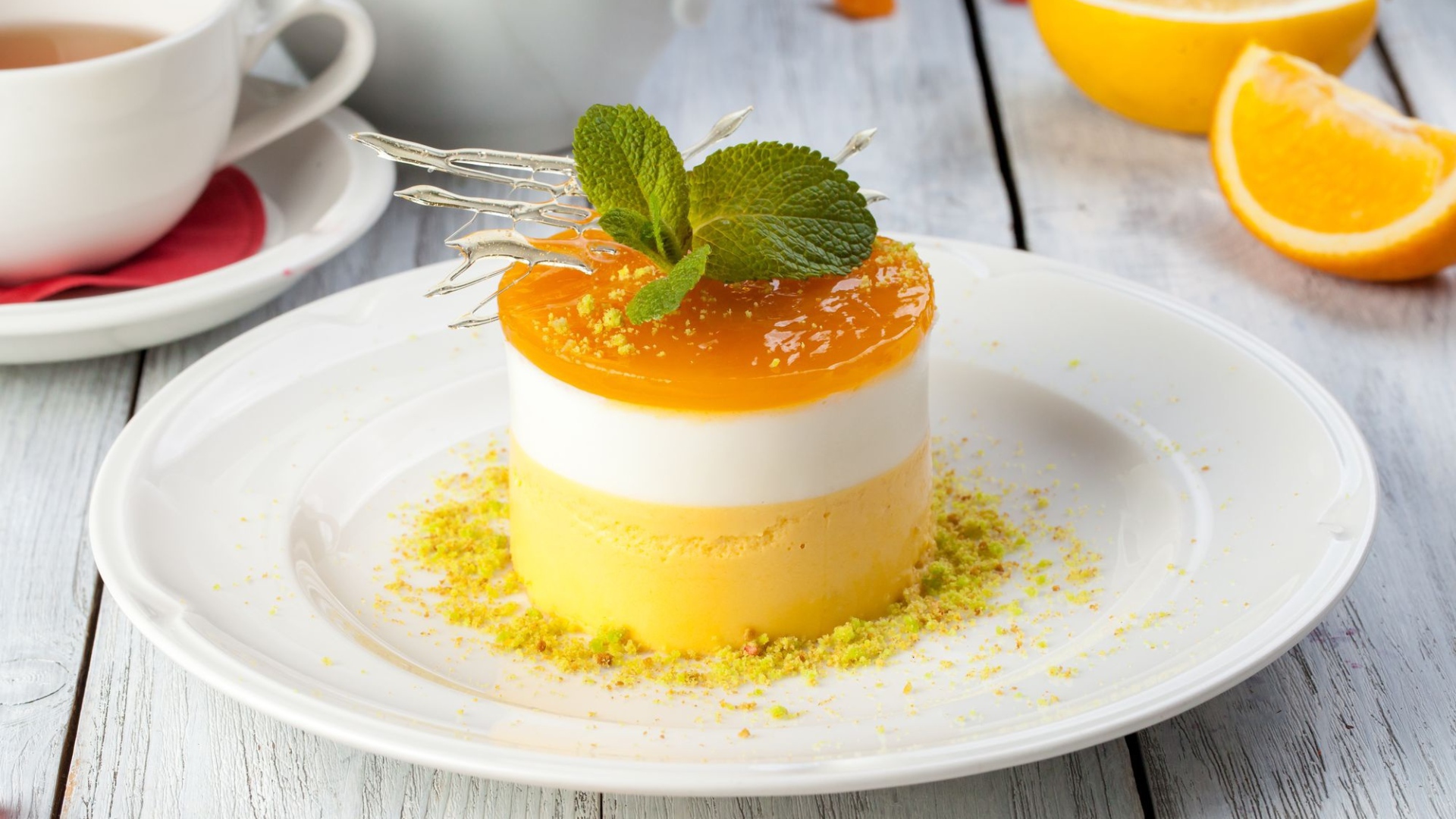 Вкусный десерт с мятой и фисташками на белой тарелке 