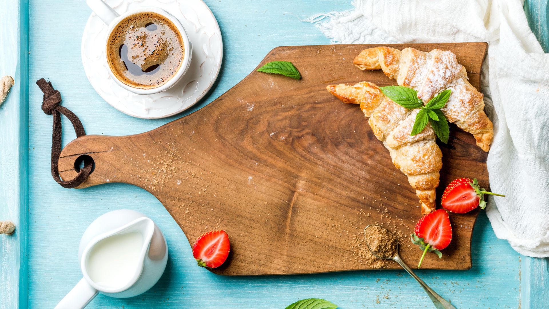 Деревянная доска на столе с круассанами и чашкой кофе