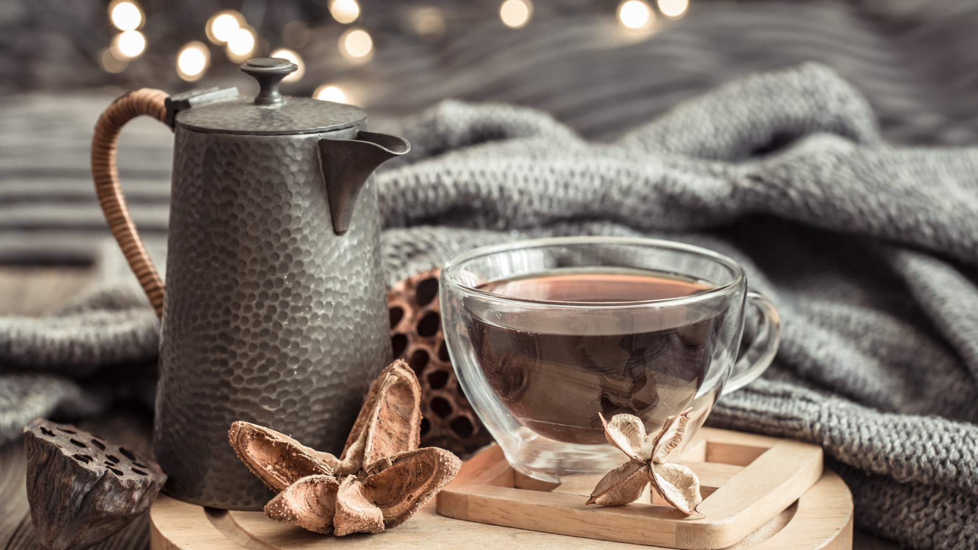 Чашка чая на столе с чайником и теплым пледом