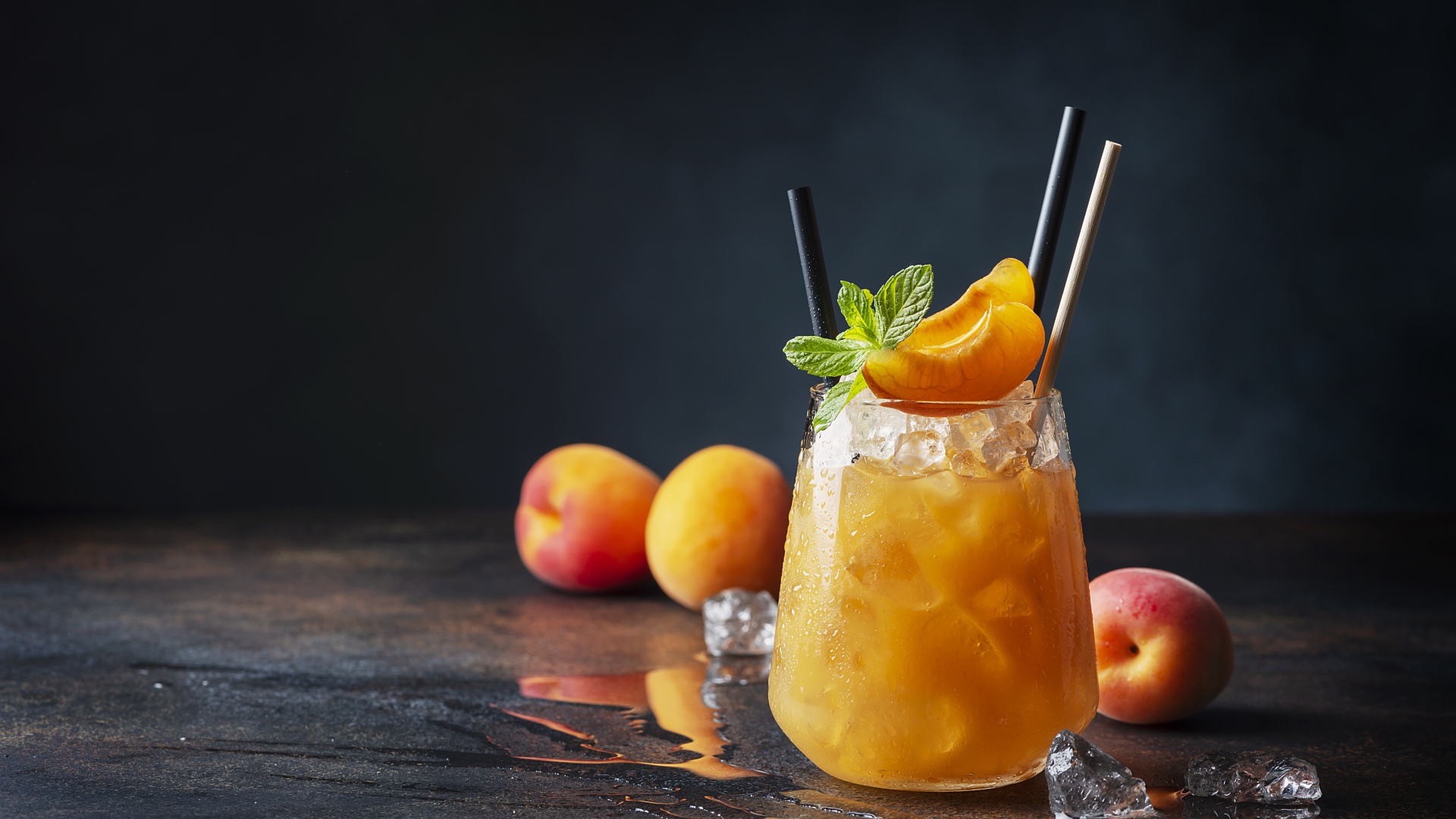 Стакан абрикосового сока со льдом в стакане 