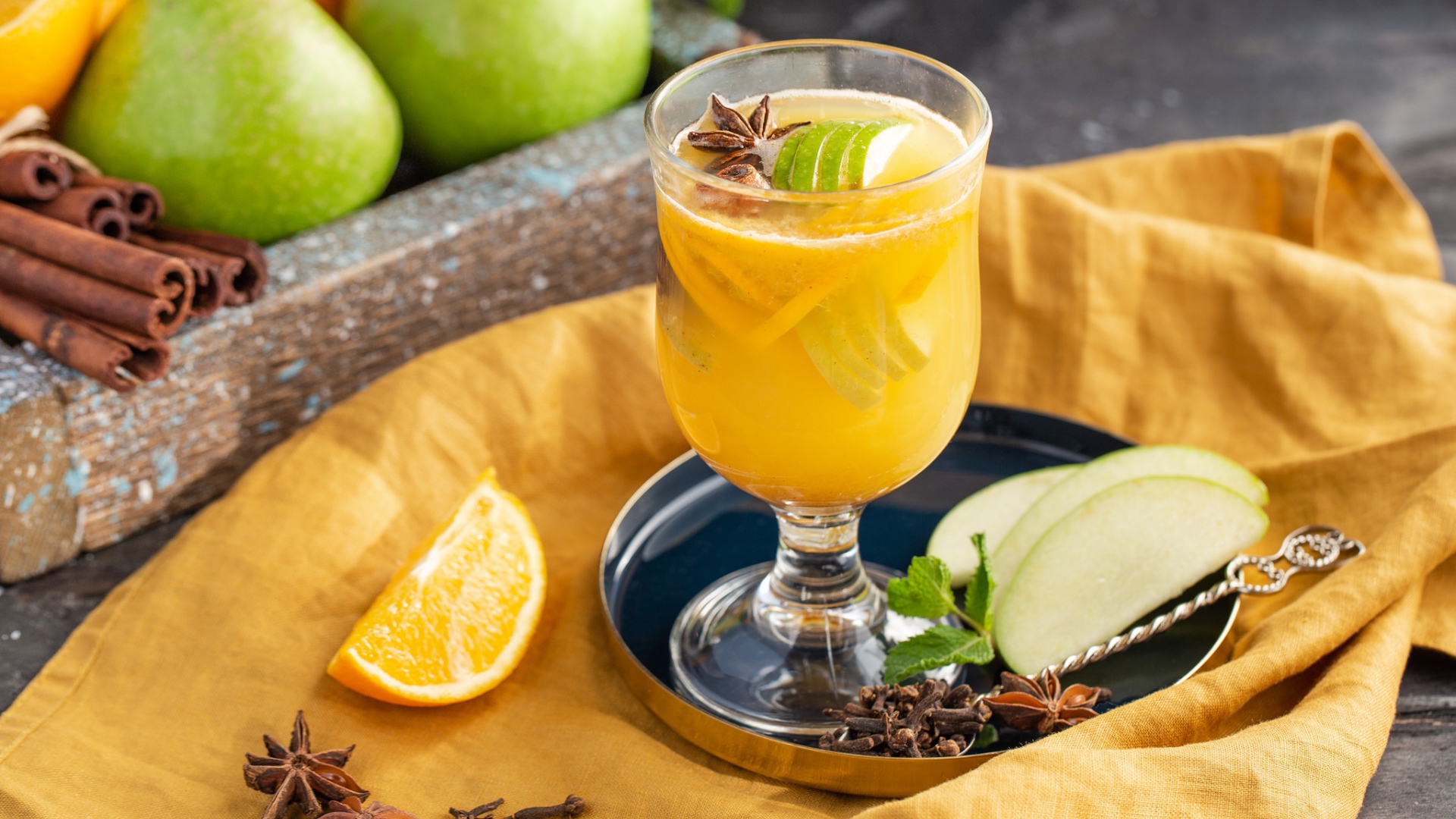 Стакан лимонада на столе с яблоками и корицей 