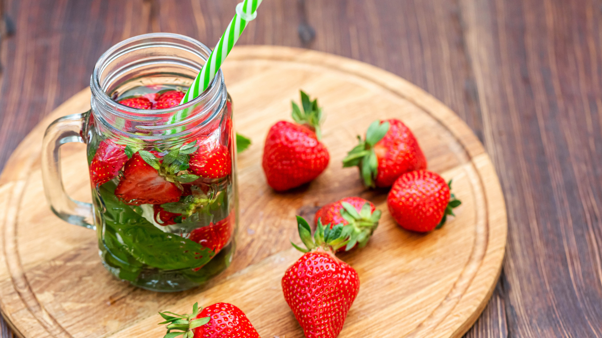 Напиток  в банке с ягодами клубники и трубочкой