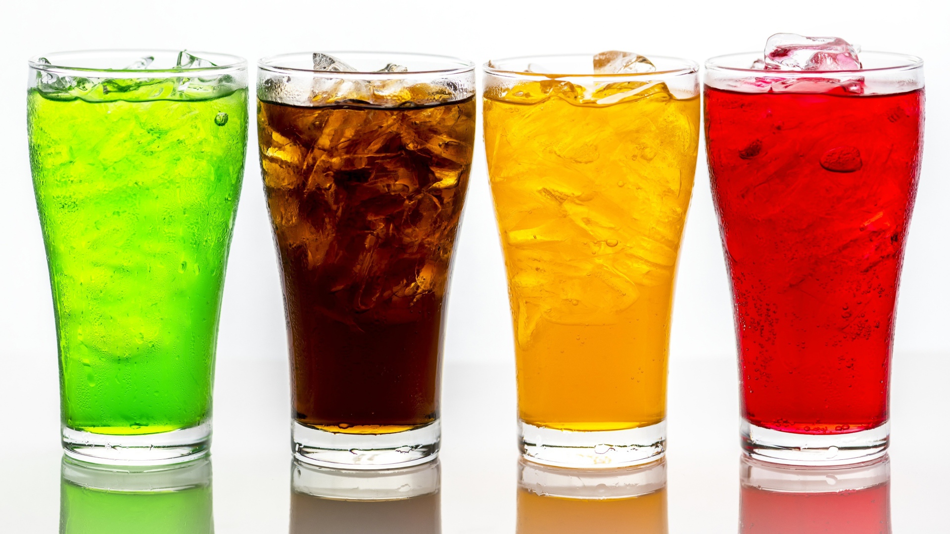 Четыре стакана с напитками на белом фоне