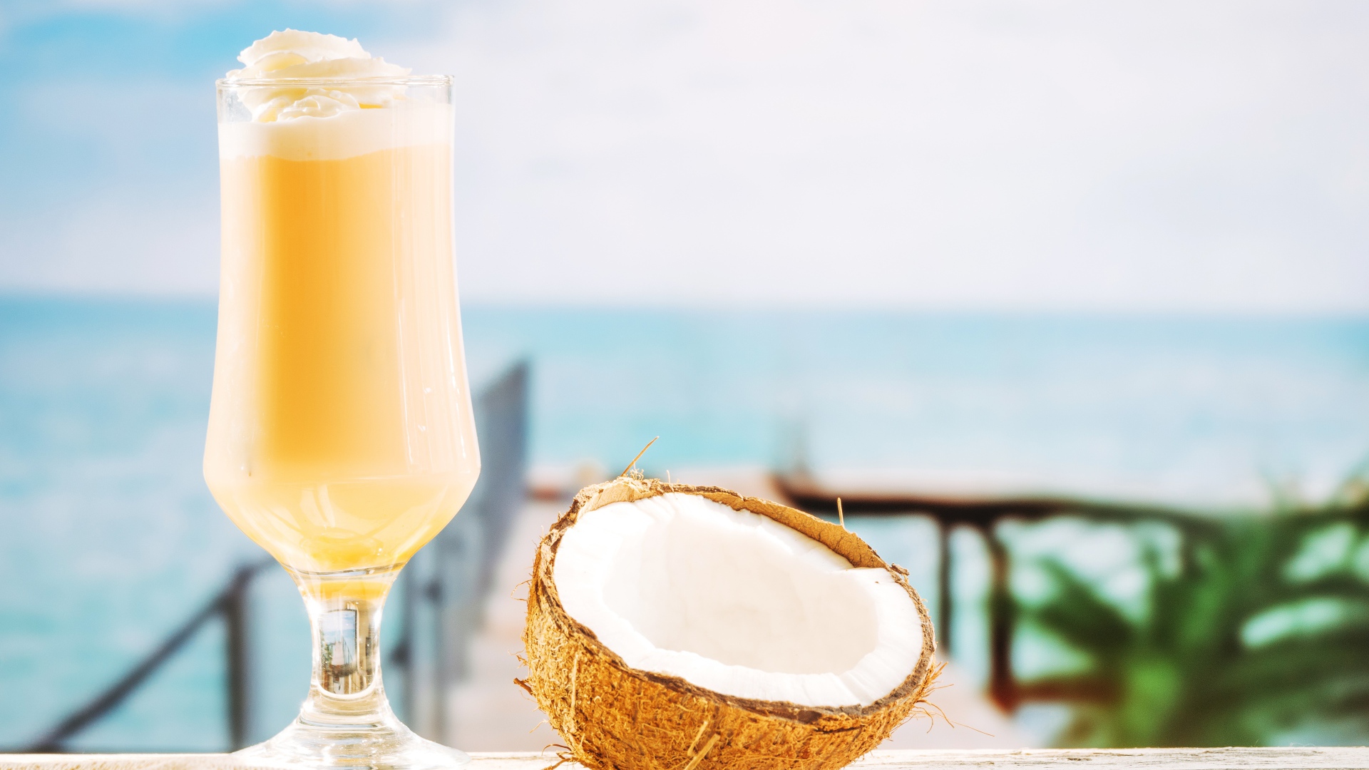 Стакан с коктейлем на столе с кокосом 