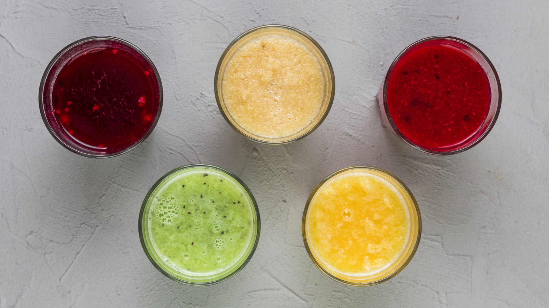 Стаканы с вкусным смузи на сером фоне