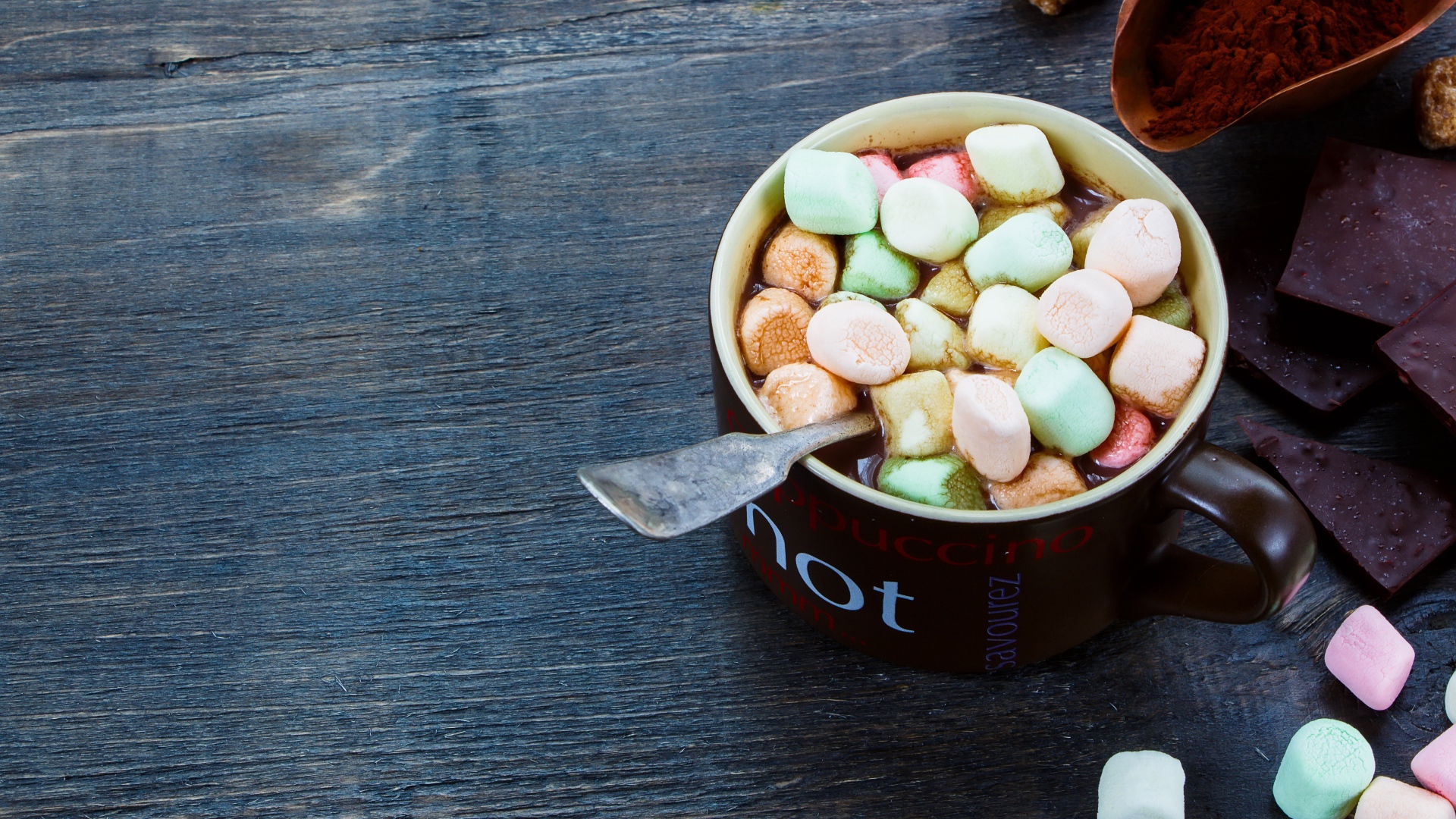 Горячий шоколад с маршмеллоу на столе с плитками