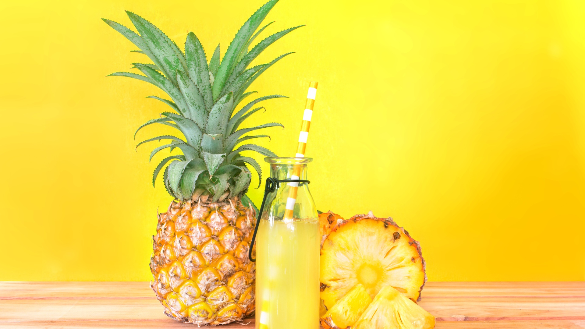 Сок в бутылке на столе с ананасами