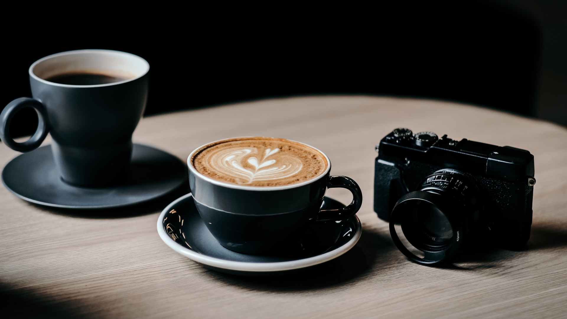 Две чашки кофе на столе с фотоаппаратом 