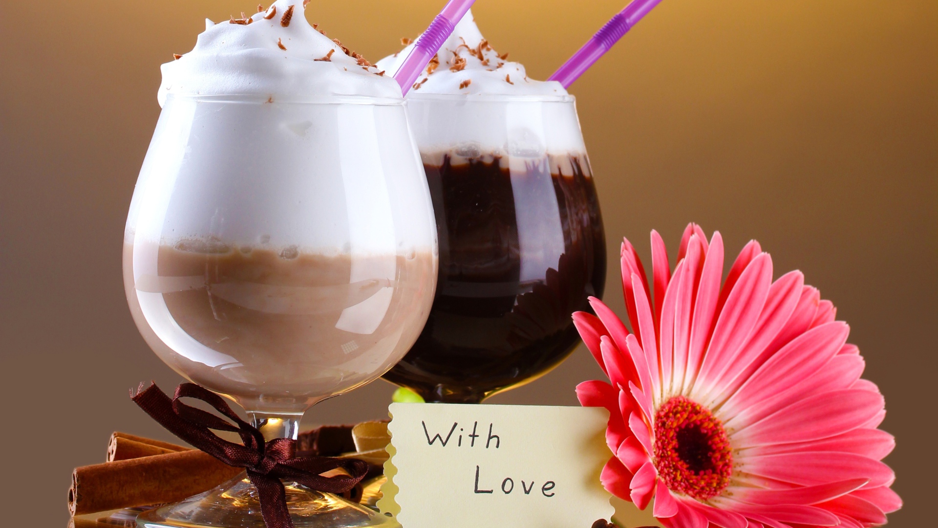 Два бокала с напитком на столе с розовой герберой