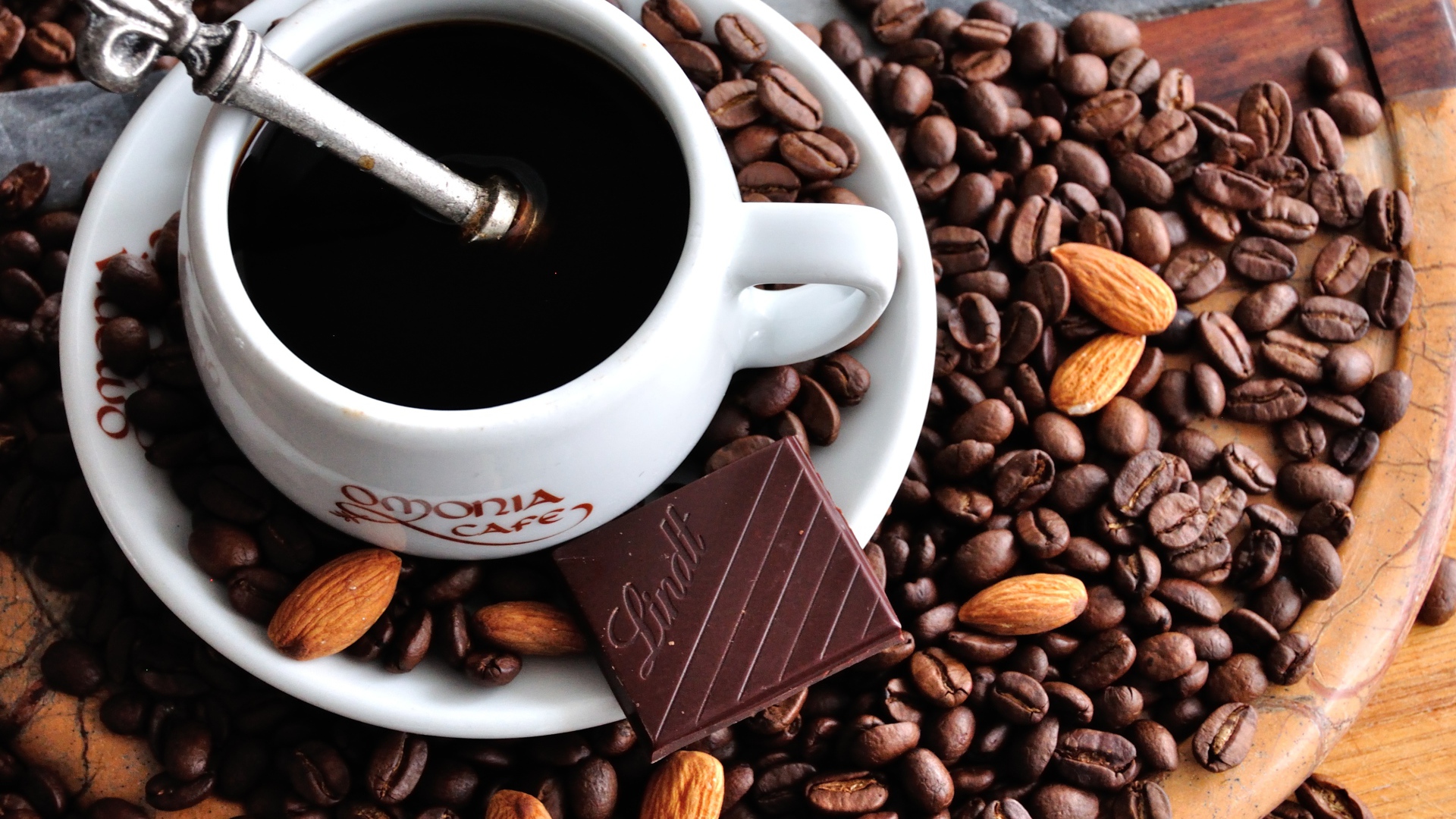 Белая чашка кофе на столе с кофейными зернами 