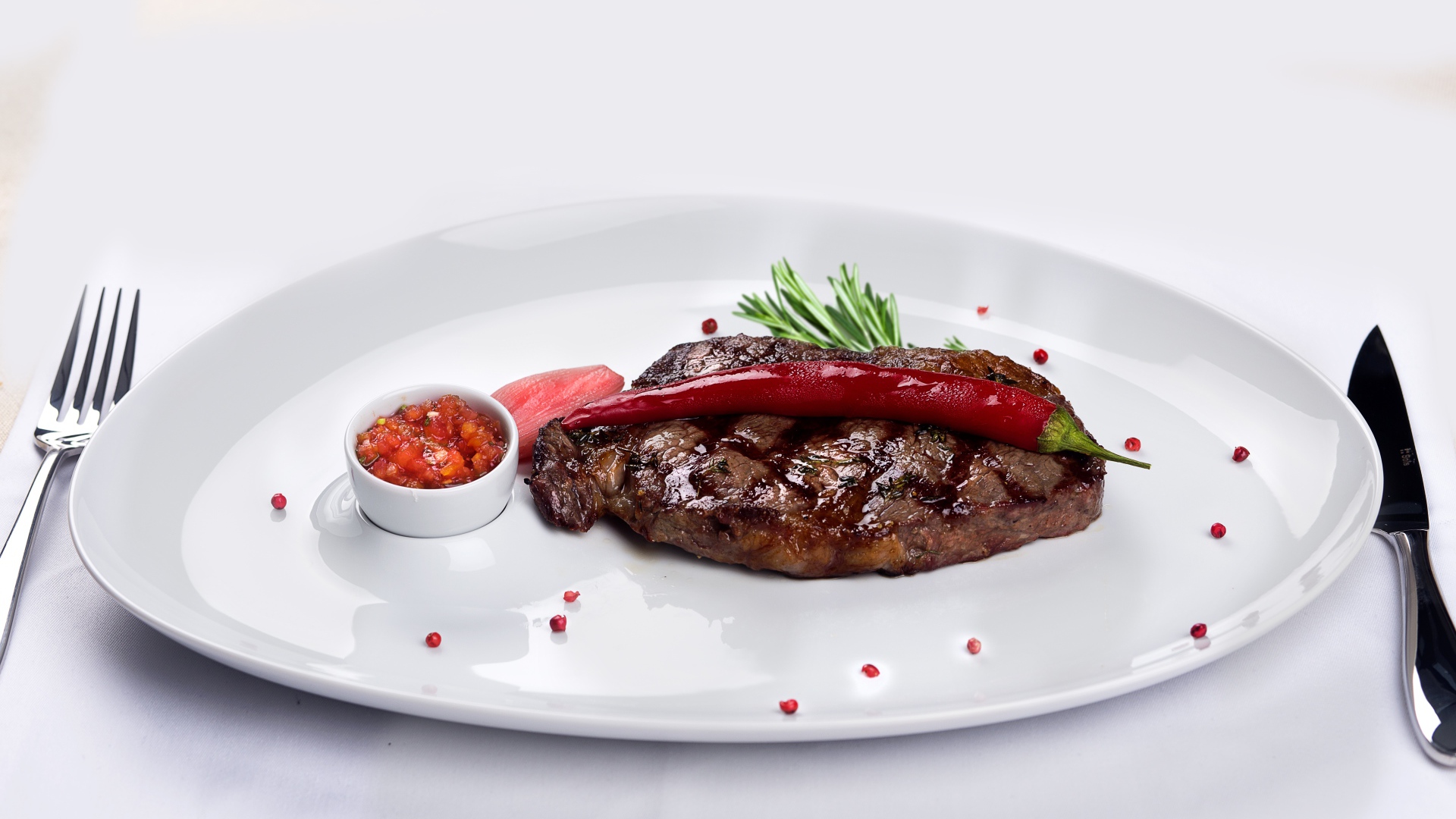 Стейк с кровью на тарелке с красным перцем