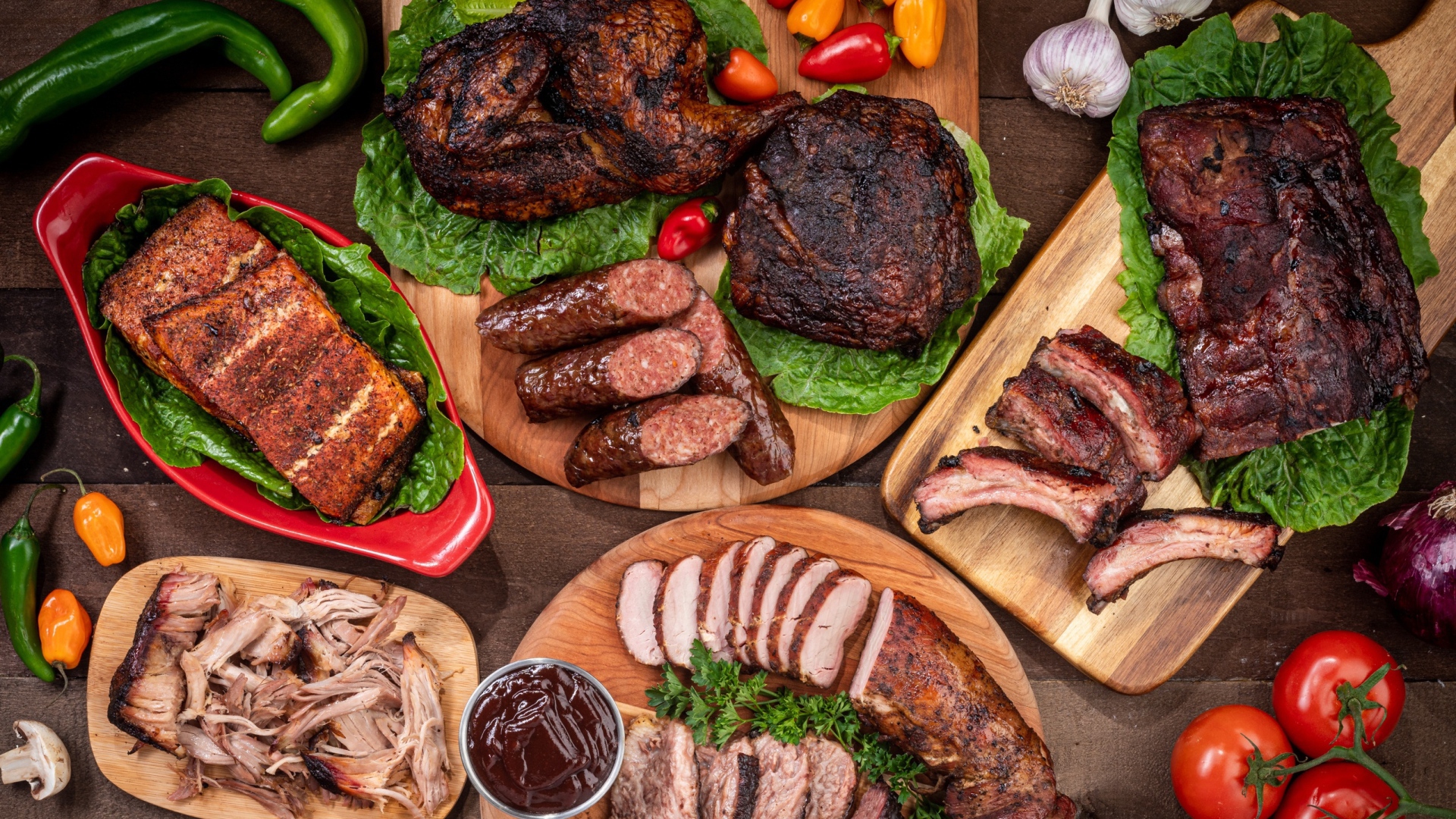 Вкусные запеченные мясные продукты на столе с овощами 