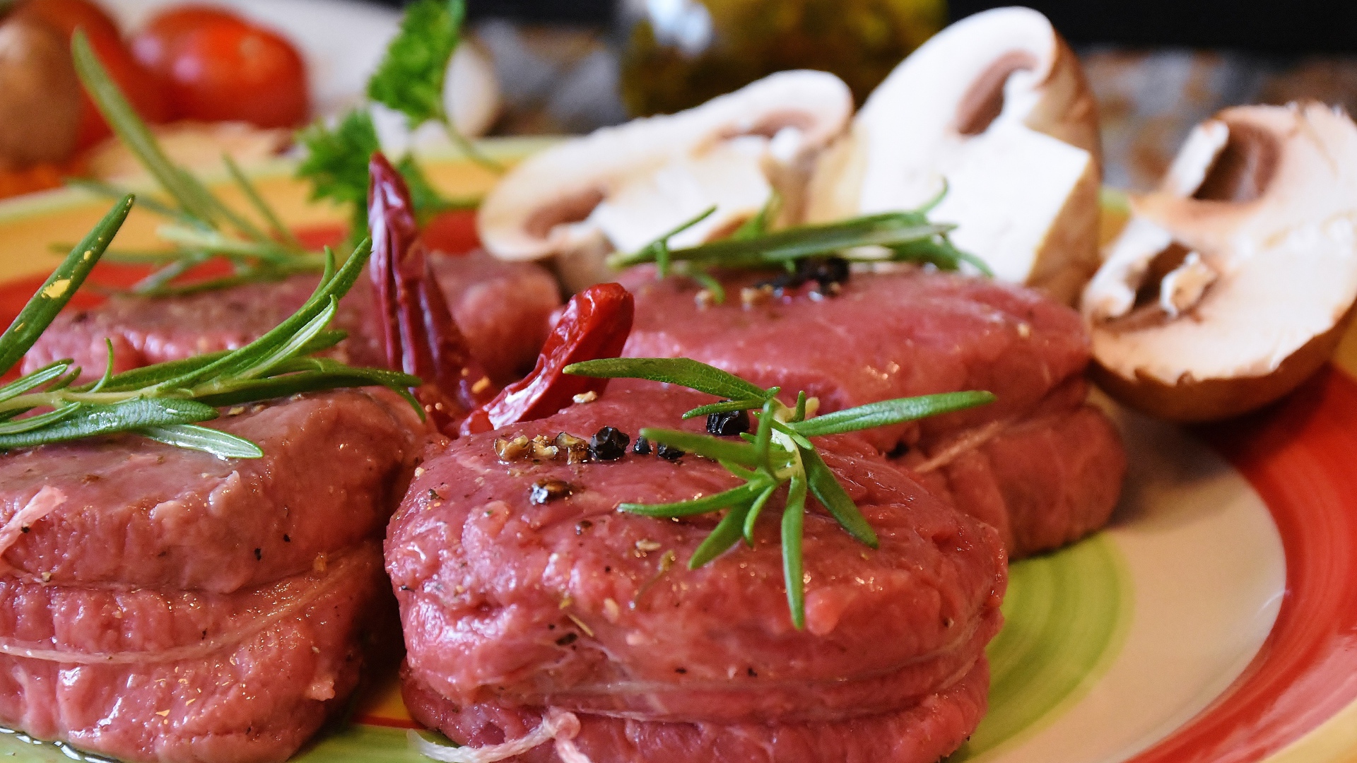 Свежее мясо маринуется со специями на столе с грибами